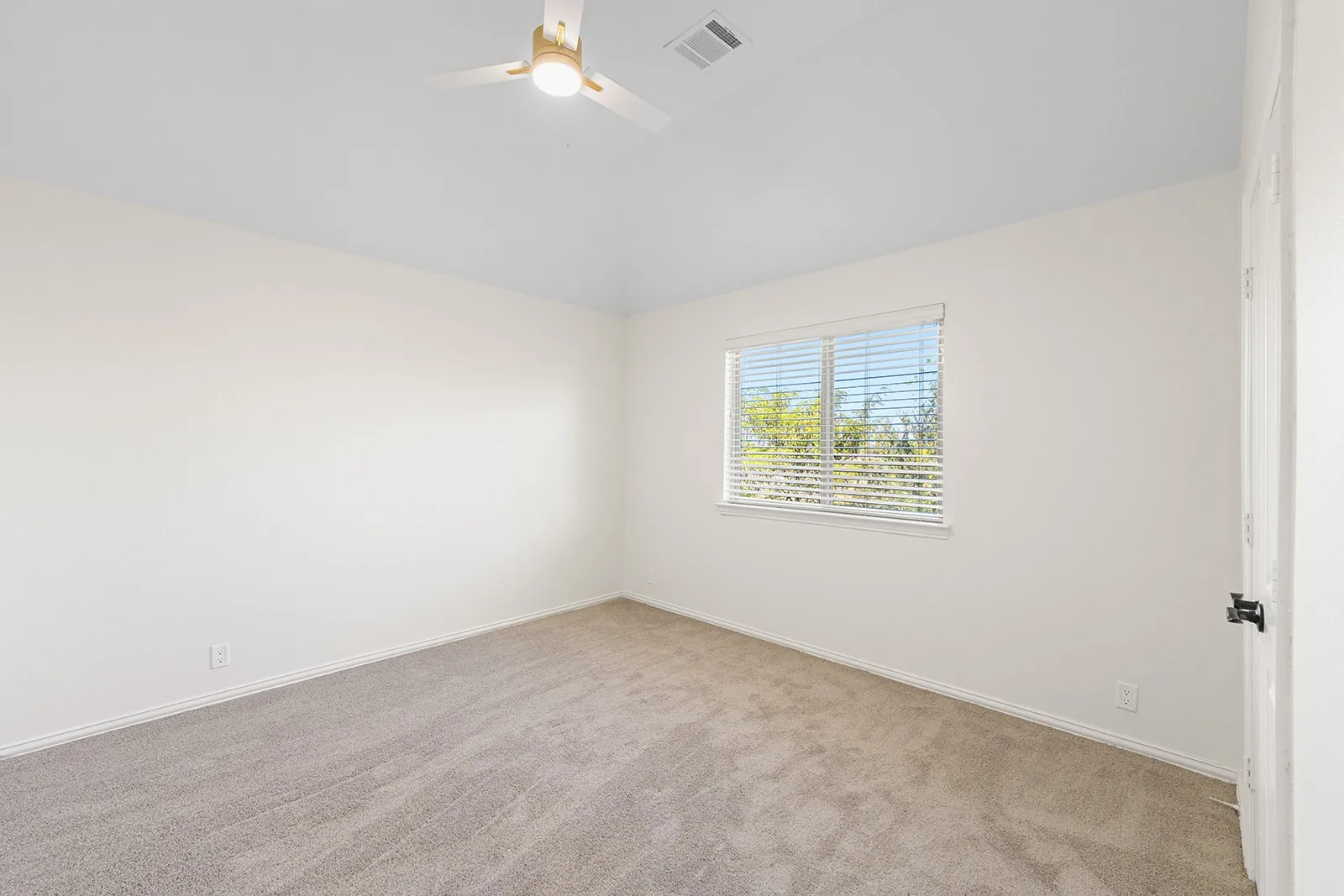 Vaulted ceiling with a ceiling fan, neutral carpeting, and a window with blinds