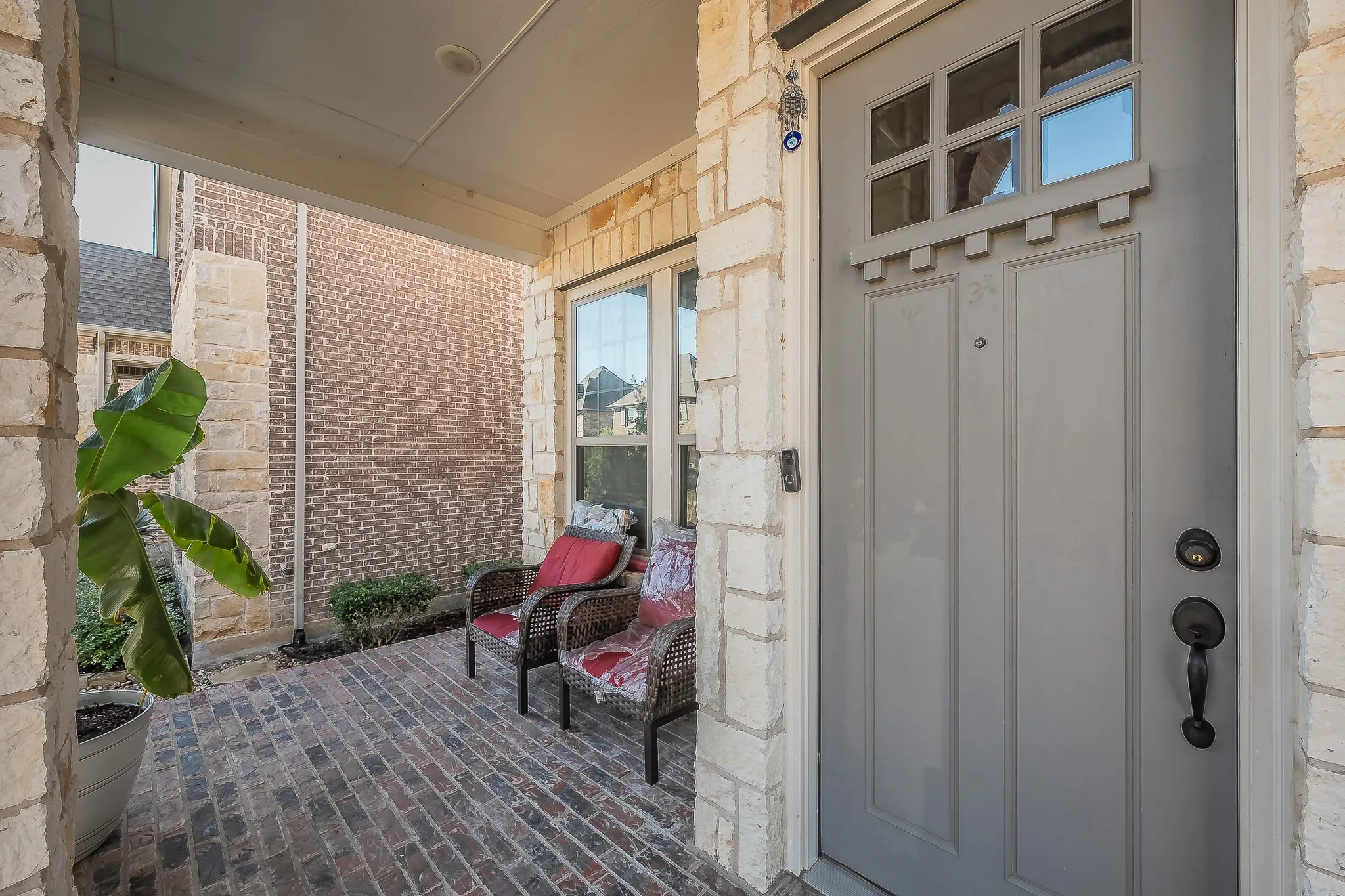 Inviting covered front porch with craftsman-style front door