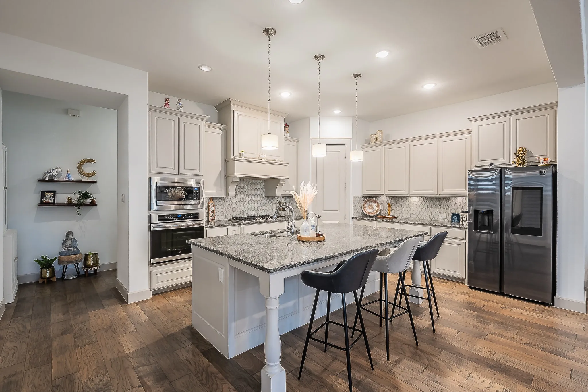 Open-concept kitchen featuring a large island with sturdy granite countertops, recessed lighting, pendant lighting, and stainless steel appliances