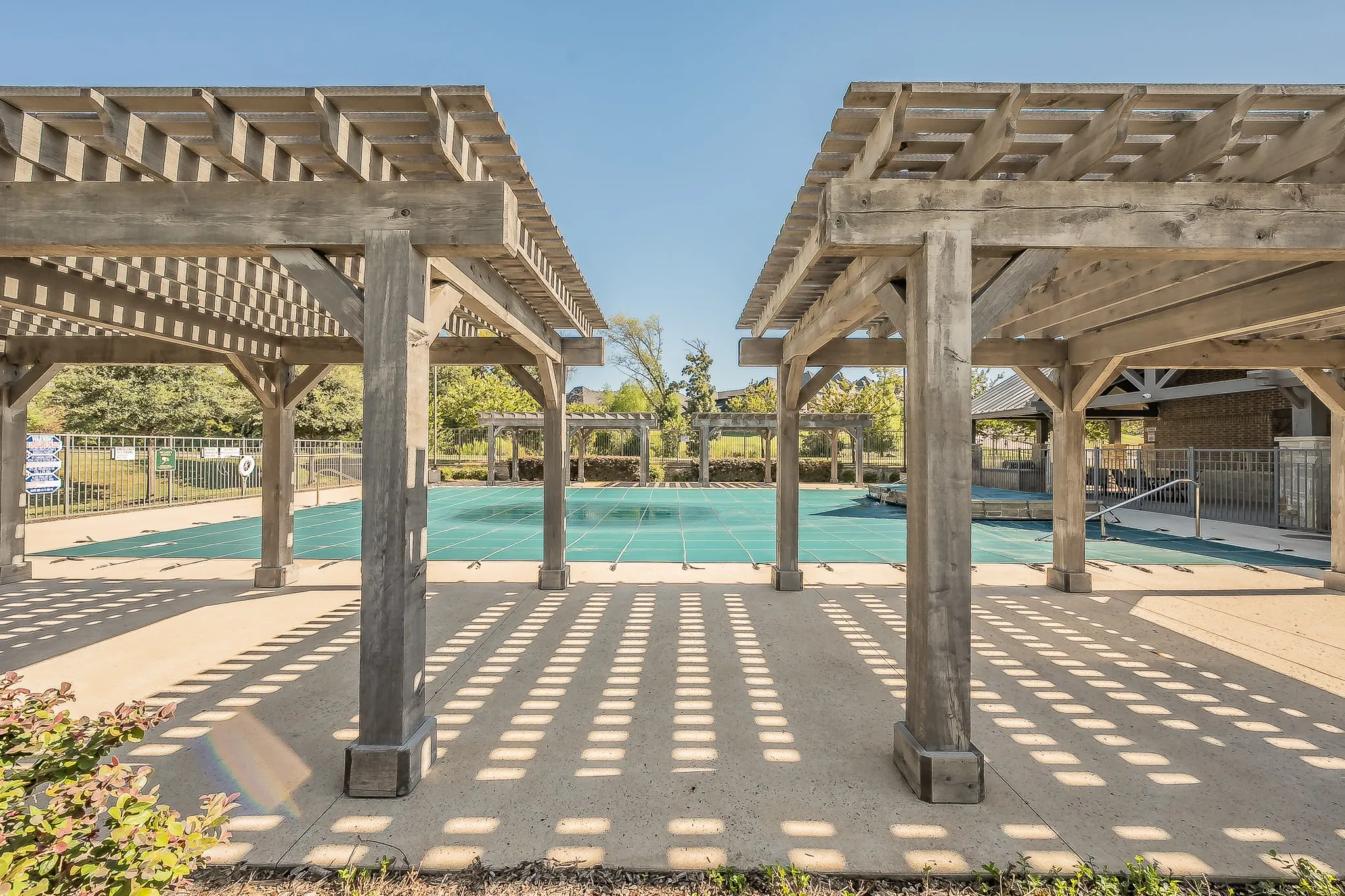 Pergolas, concrete patio, and fenced community swimming pool and grilling area with bathrooms for your enjoyment