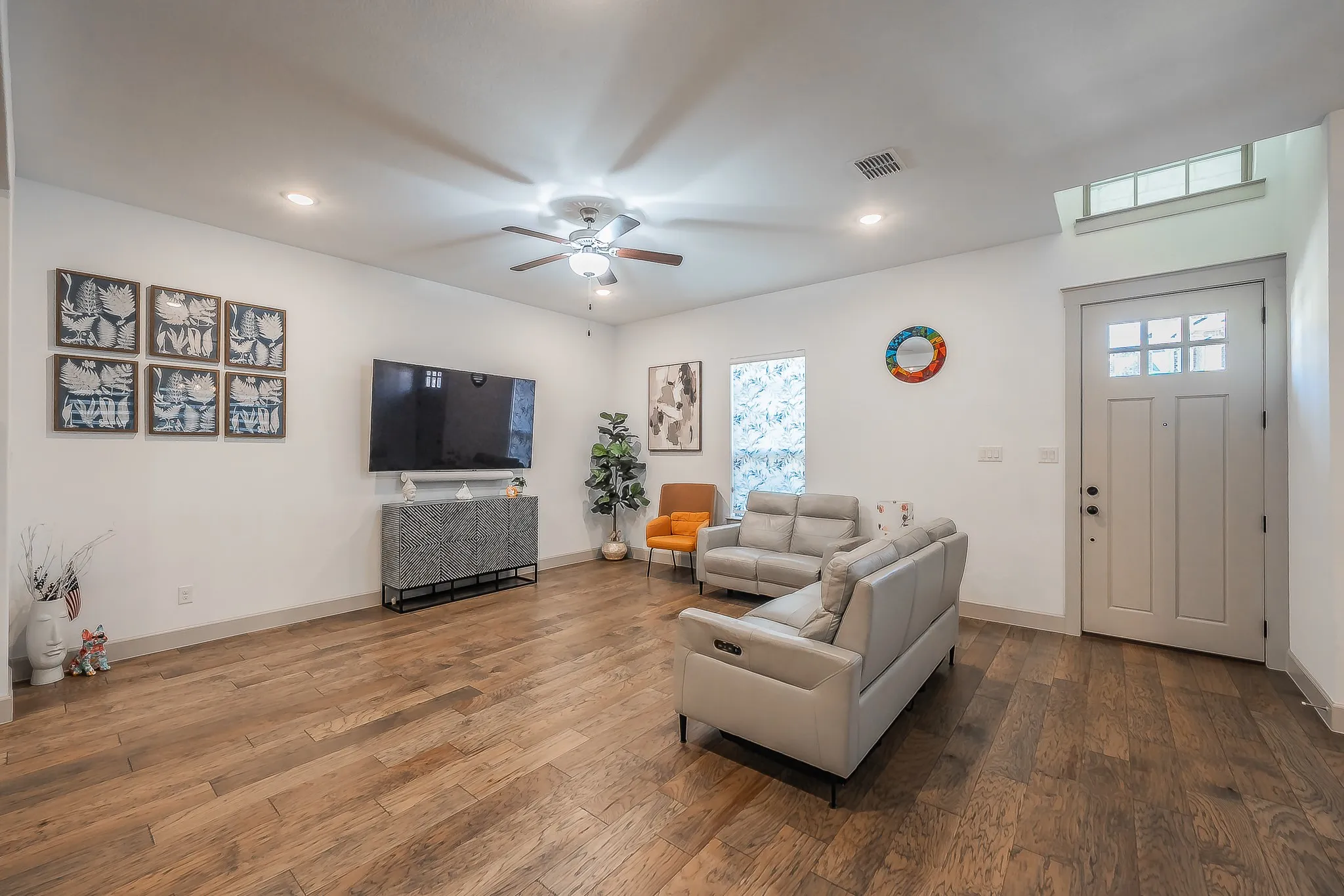 Open-concept living area featuring wood flooring, recessed lighting, and a ceiling fan