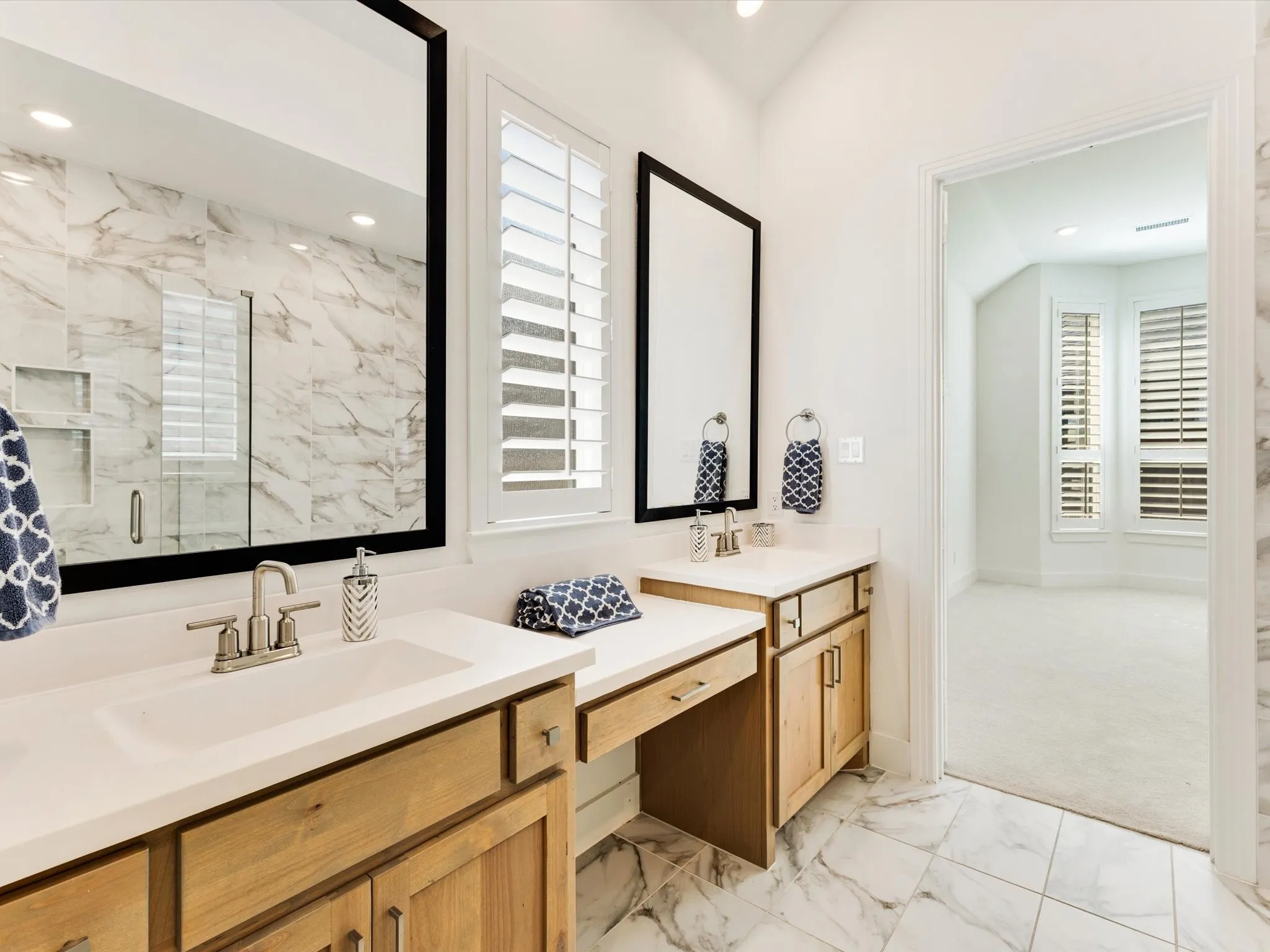 Dual vanity with light wood-finish cabinetry and light-toned countertops