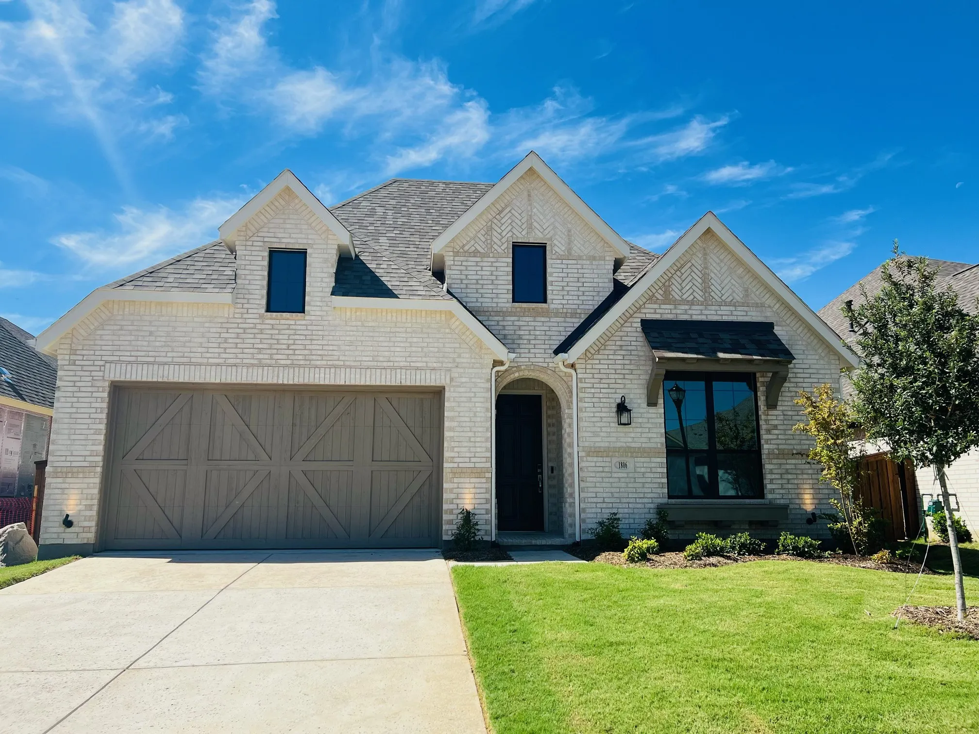 Light brick exterior with decorative gables and a dark shingle roof