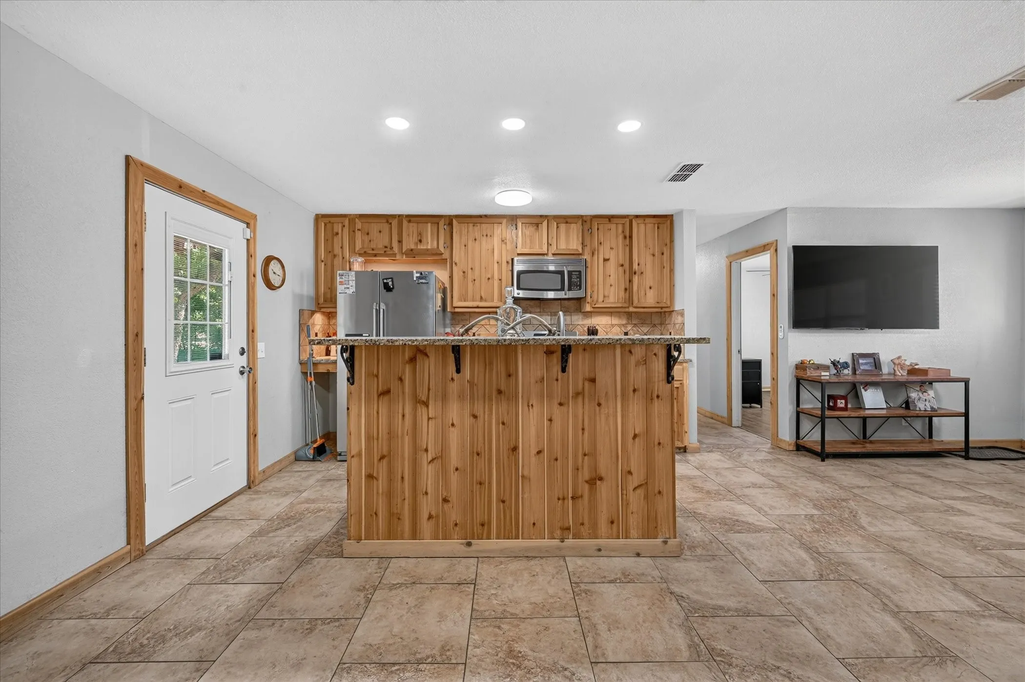 Kitchen with knotty wood cabinetry, granite-look countertops, and stainless steel appliances