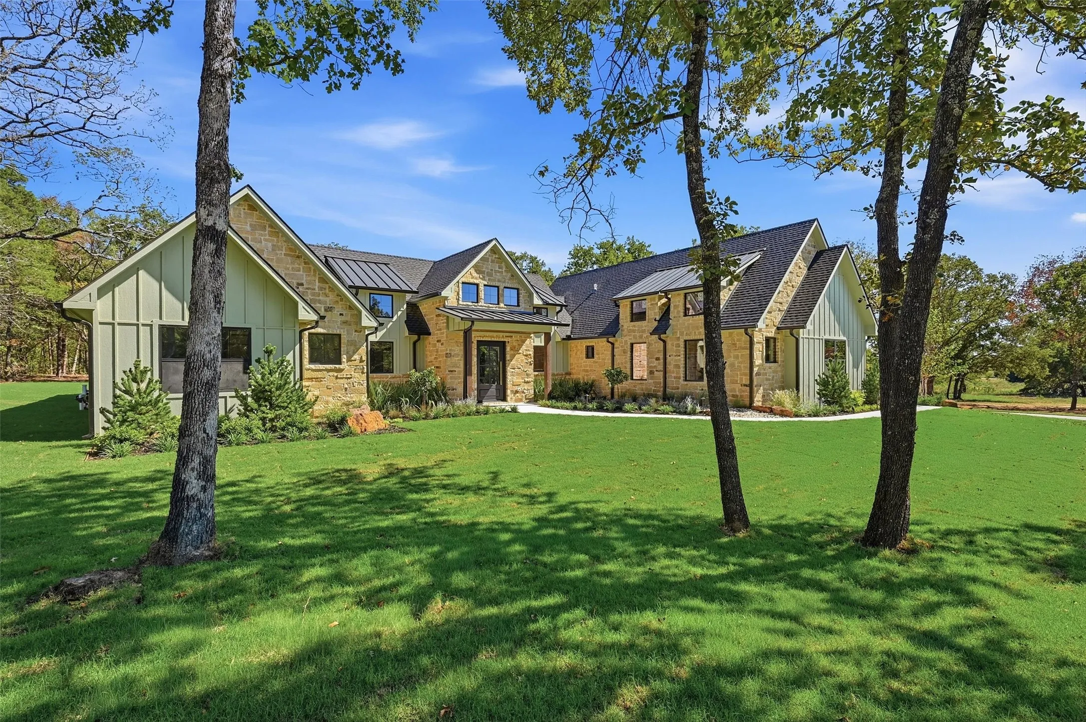 Stone and vertical siding exterior with a dark-pitched roof