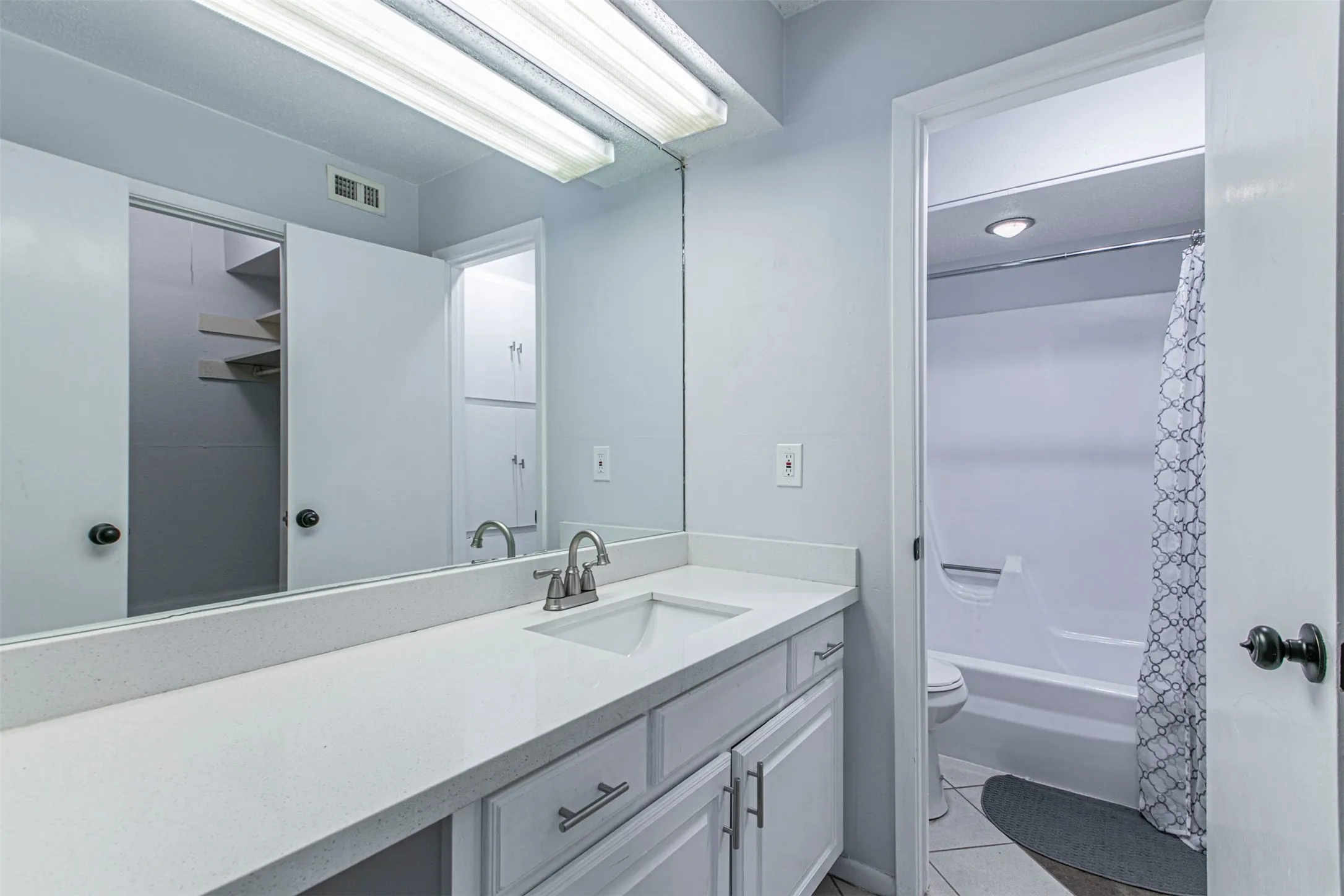 Bathroom2 with vanity, shower / bath combination with curtain, and light tile patterned floors