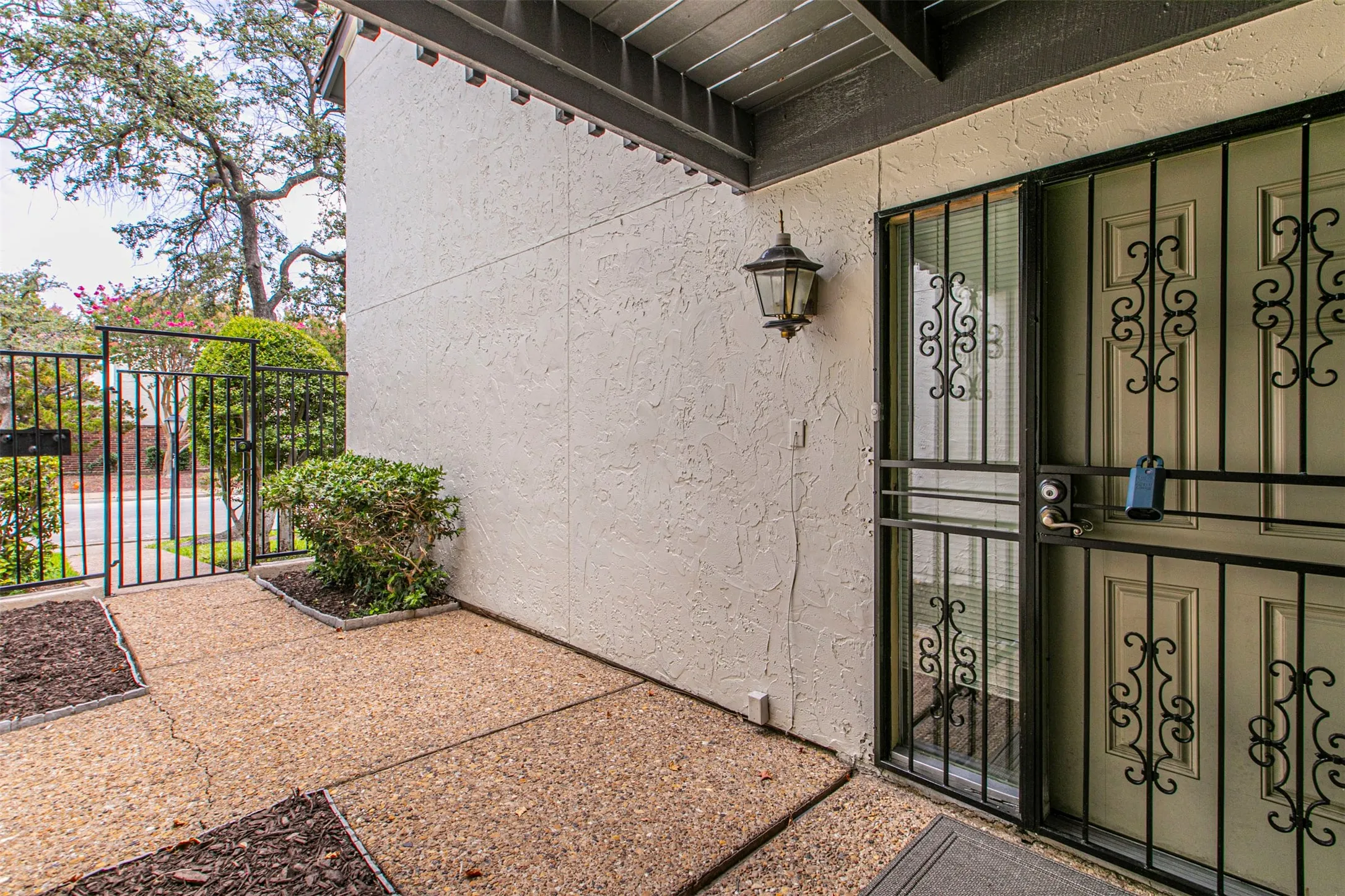 Property entrance featuring a gate and stucco siding