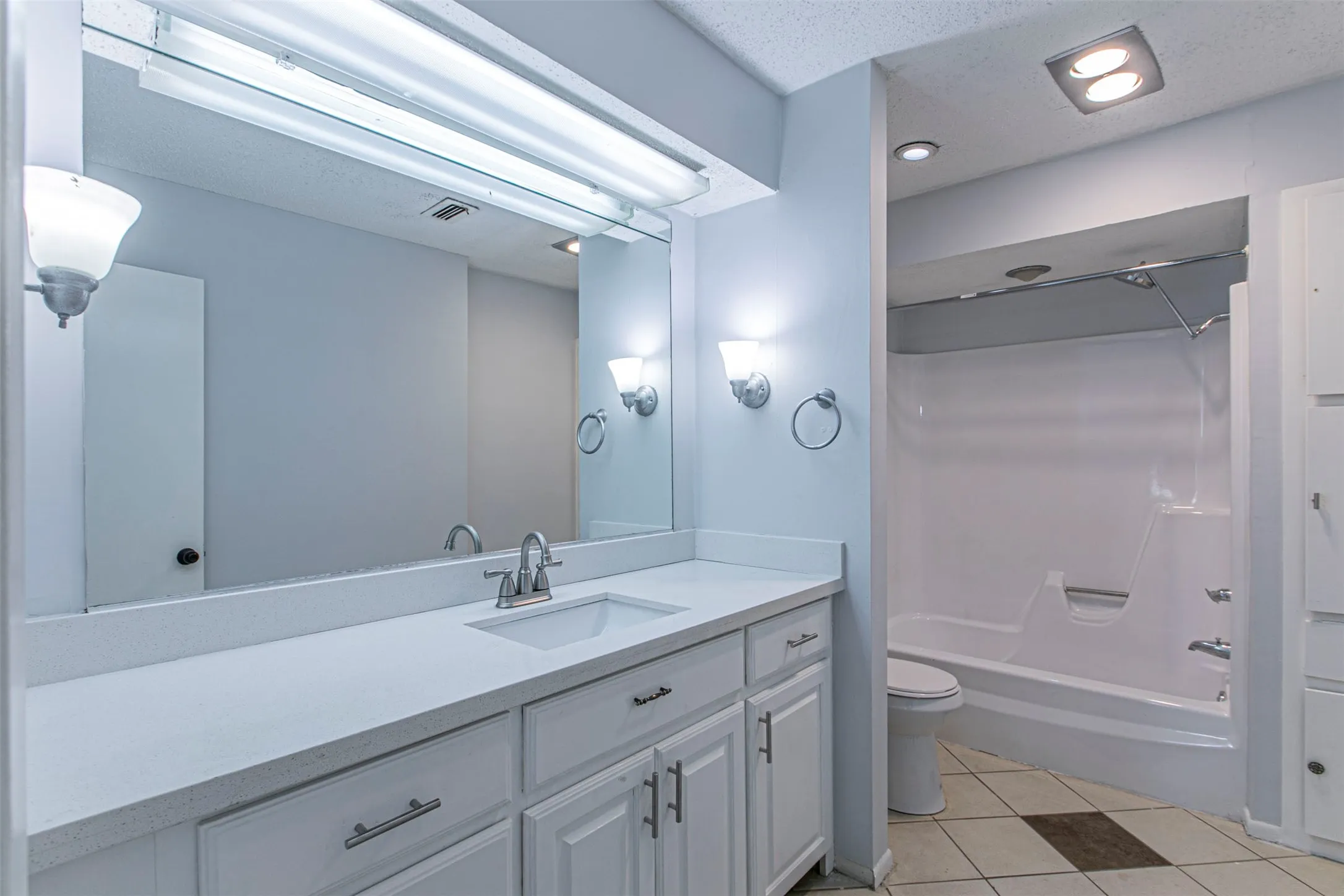 Bathroom1 featuring shower / washtub combination, light tile patterned floors, vanity, a textured ceiling, and recessed lighting