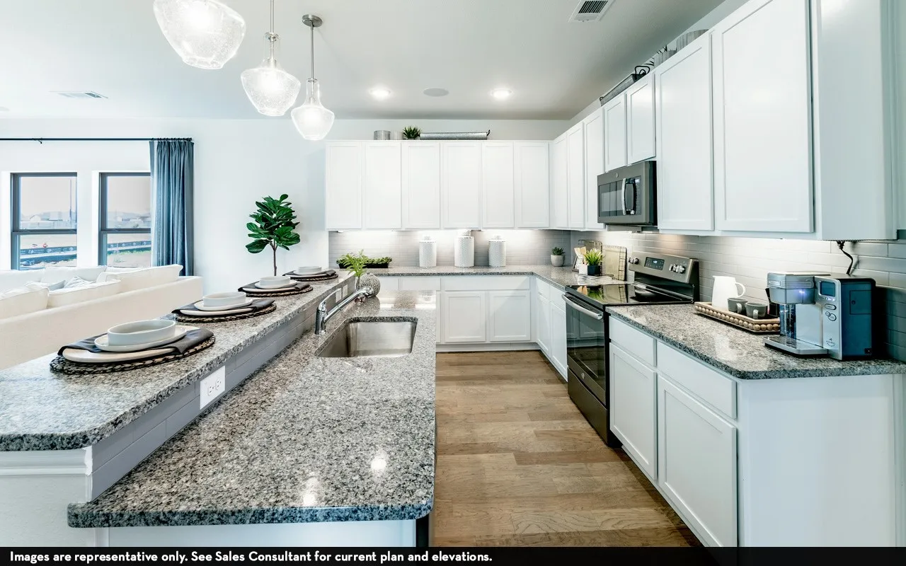 Kitchen with white cabinetry, stainless steel appliances, granite countertops, wood-finish flooring, and pendant lighting