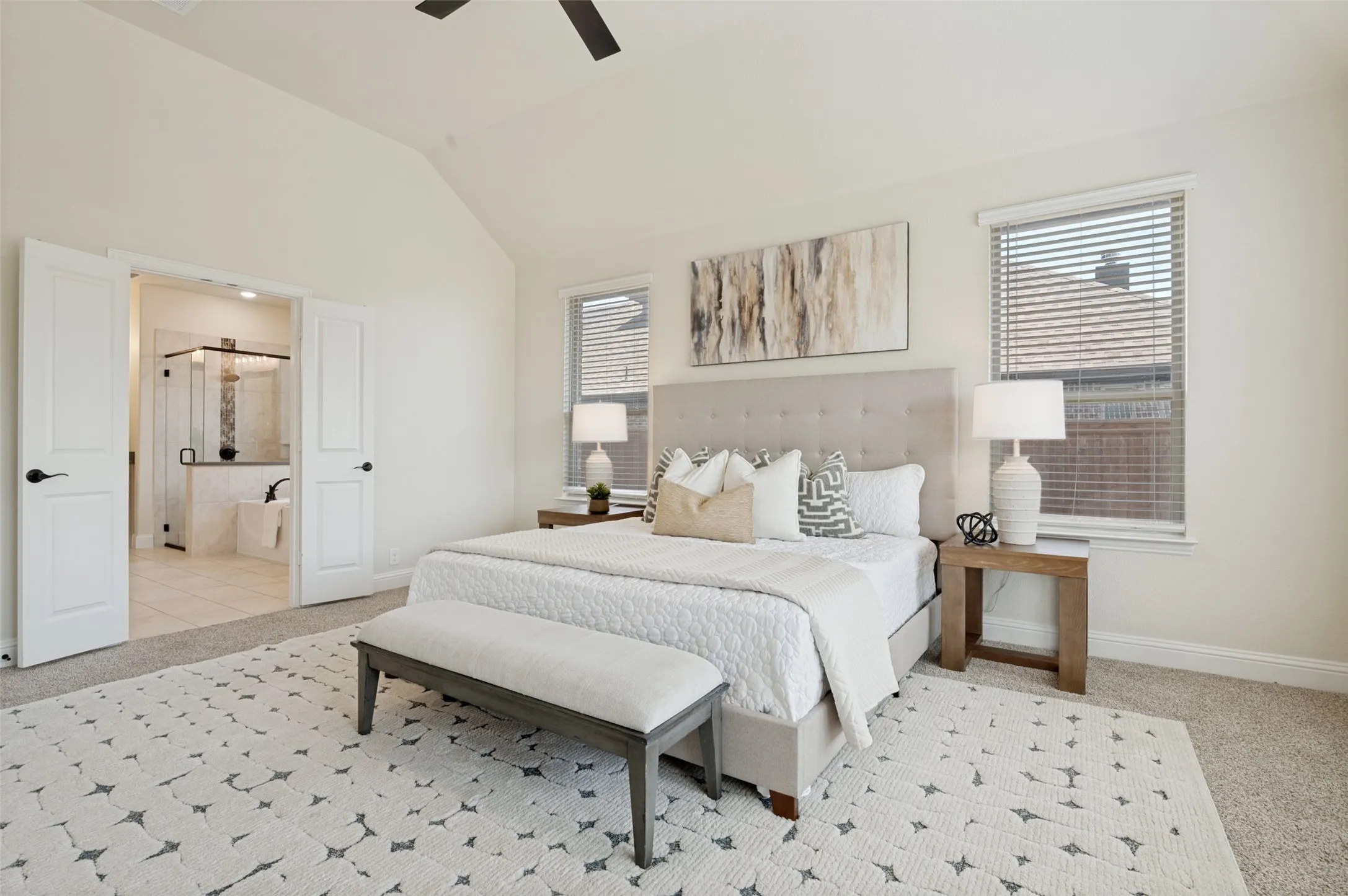 Vaulted ceiling with a ceiling fan, carpeted flooring, and white interior doors