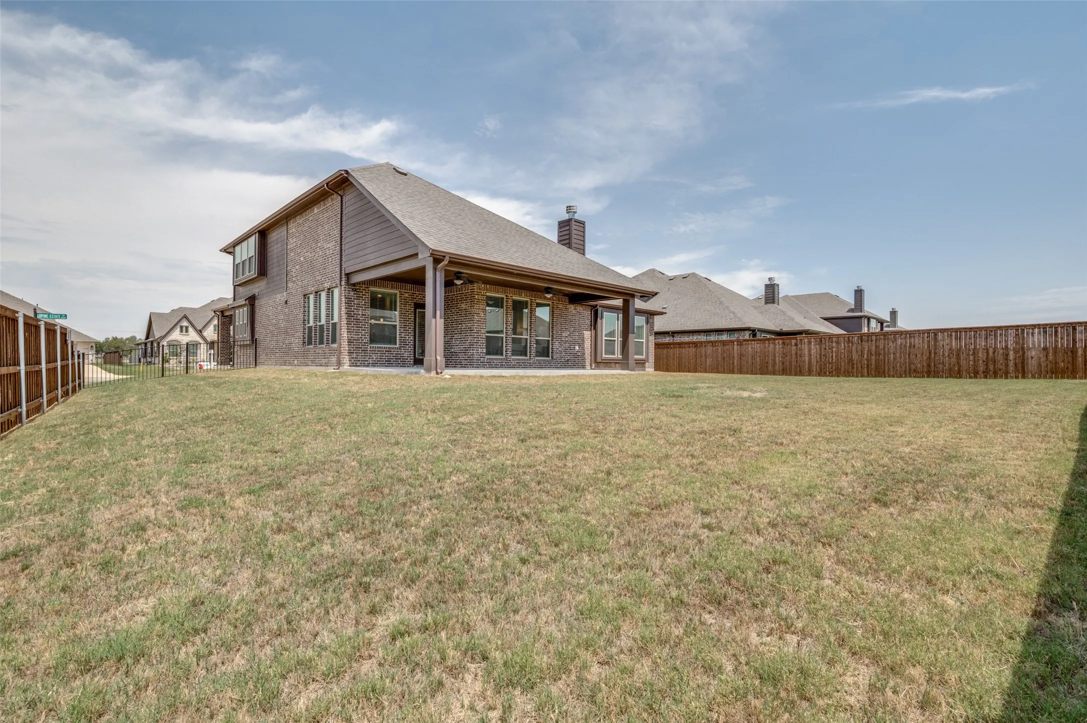 Expansive backyard with a full privacy fence and a covered patio