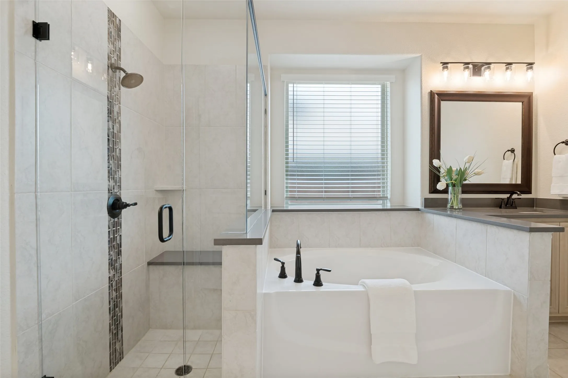 Walk-in shower with clear glass enclosure and integrated bench