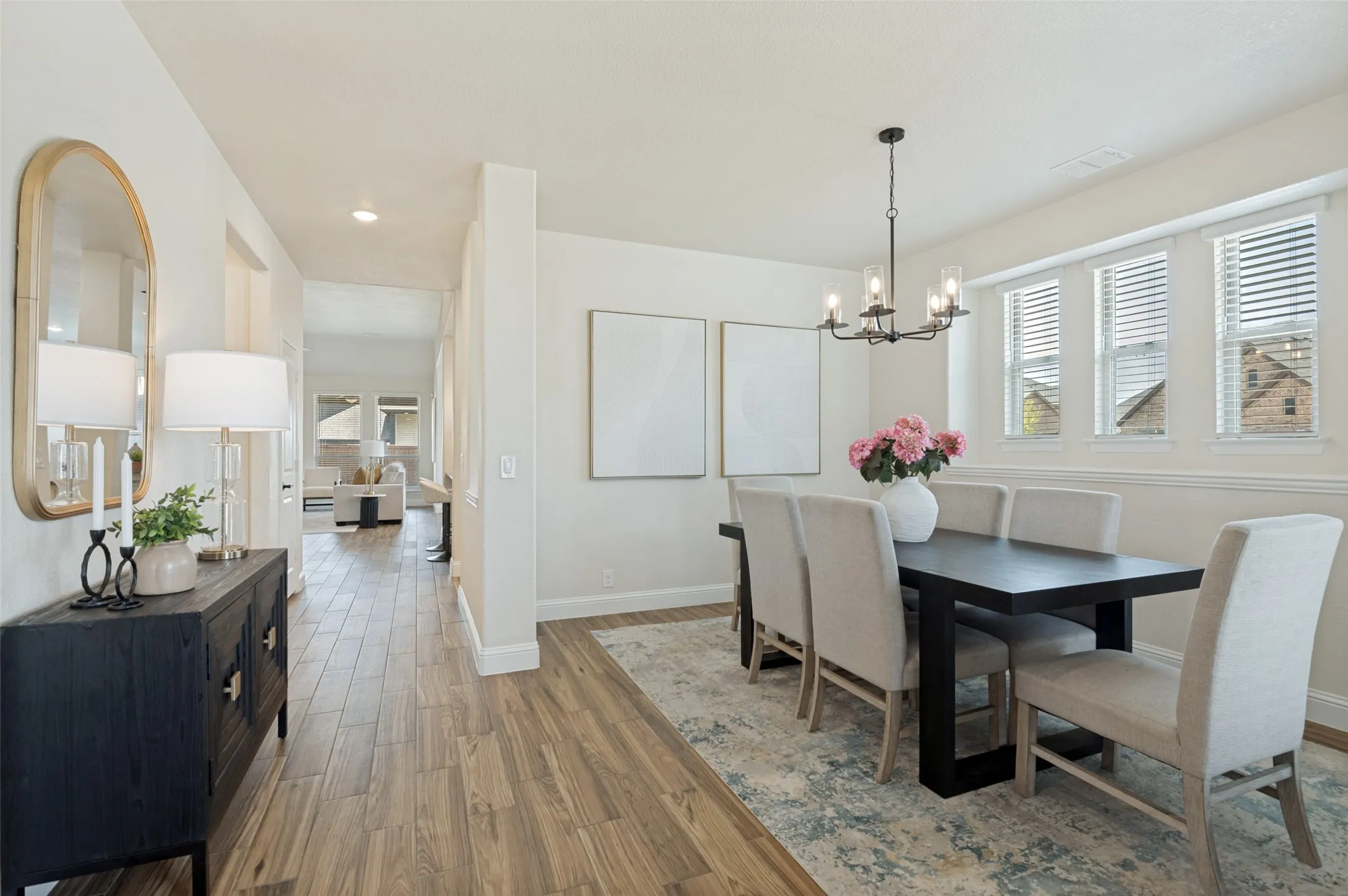 Dining area featuring wood-finish flooring, a contemporary chandelier, and multiple windows