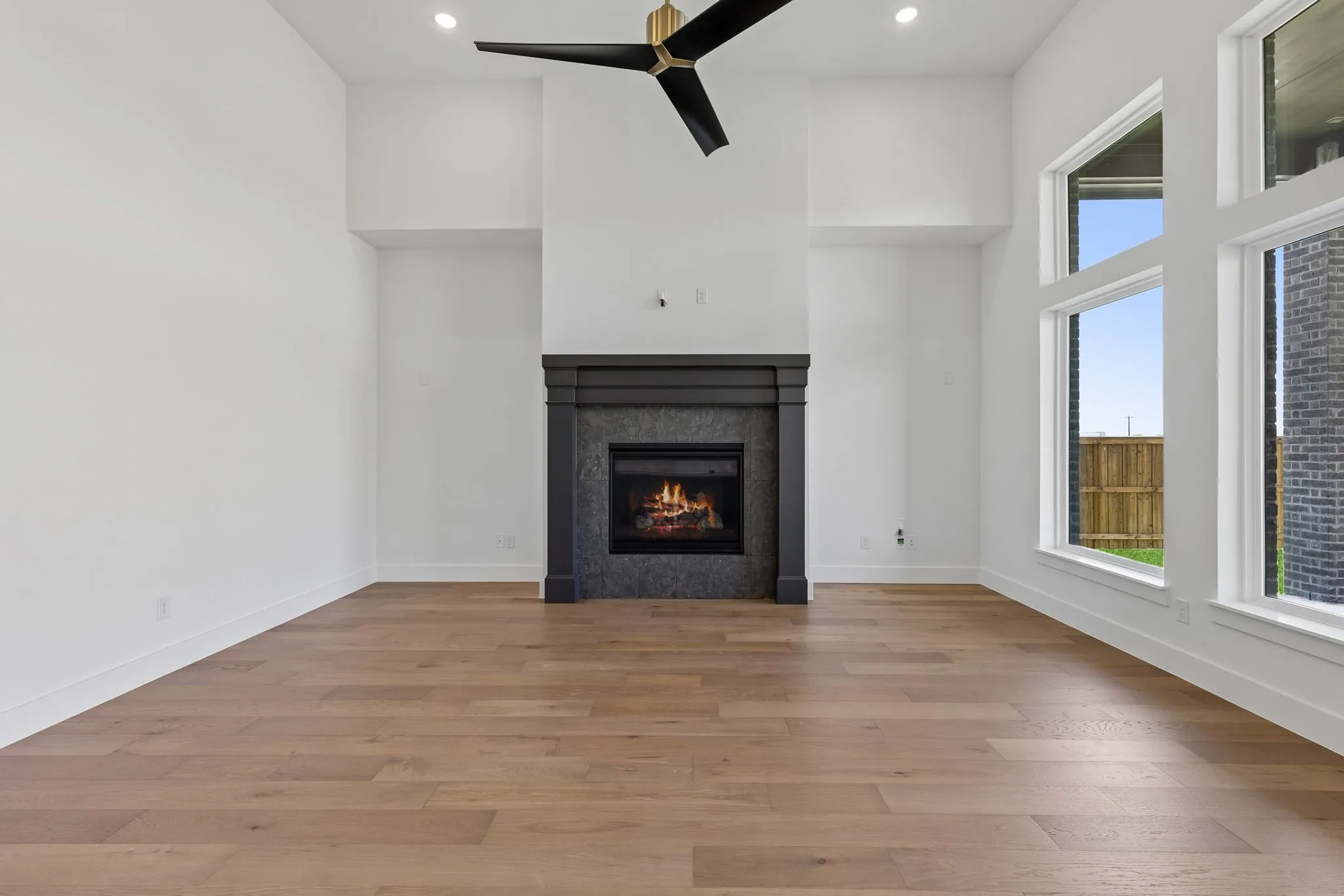 Featuring beautiful flooring with a striking dark fireplace set against neutral colored walls, this over the top family room is the perfect place for memories to be made!