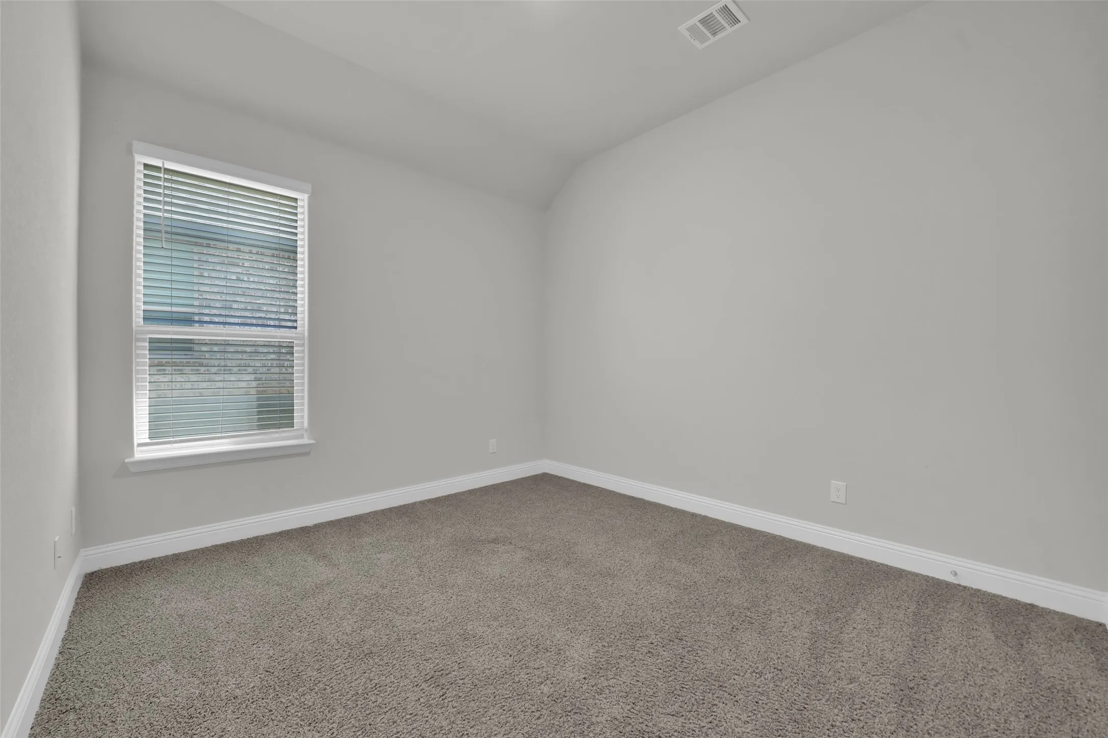 Carpeted flooring, neutral wall tones, white trim, and a window with blinds