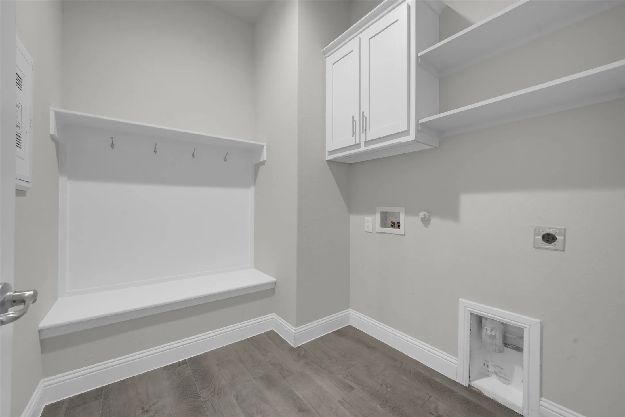 Built-in bench with coat hooks, wood-finish flooring, overhead cabinetry, and open shelving