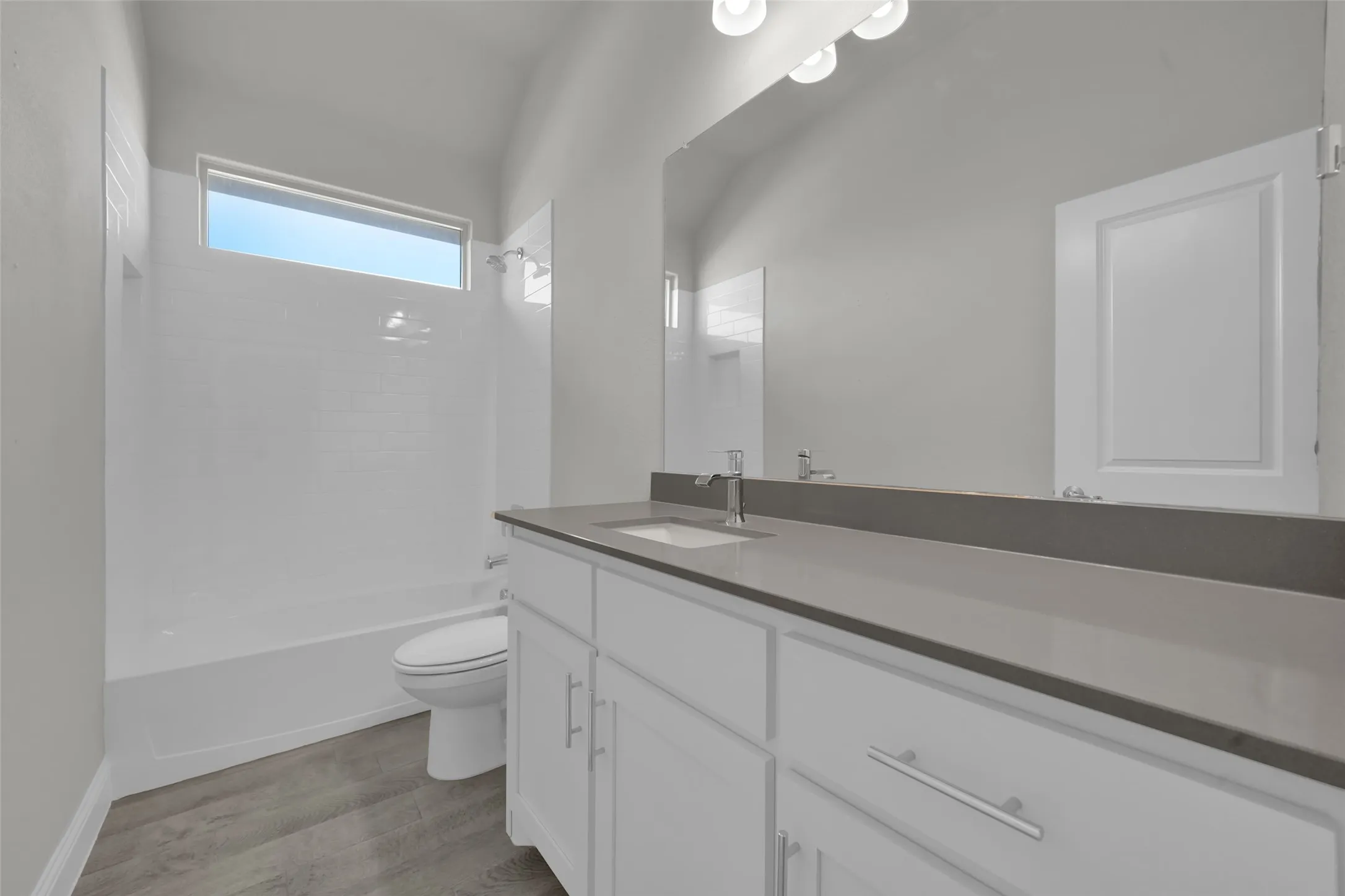 Single vanity with a light gray countertop, undermount sink, and chrome faucet