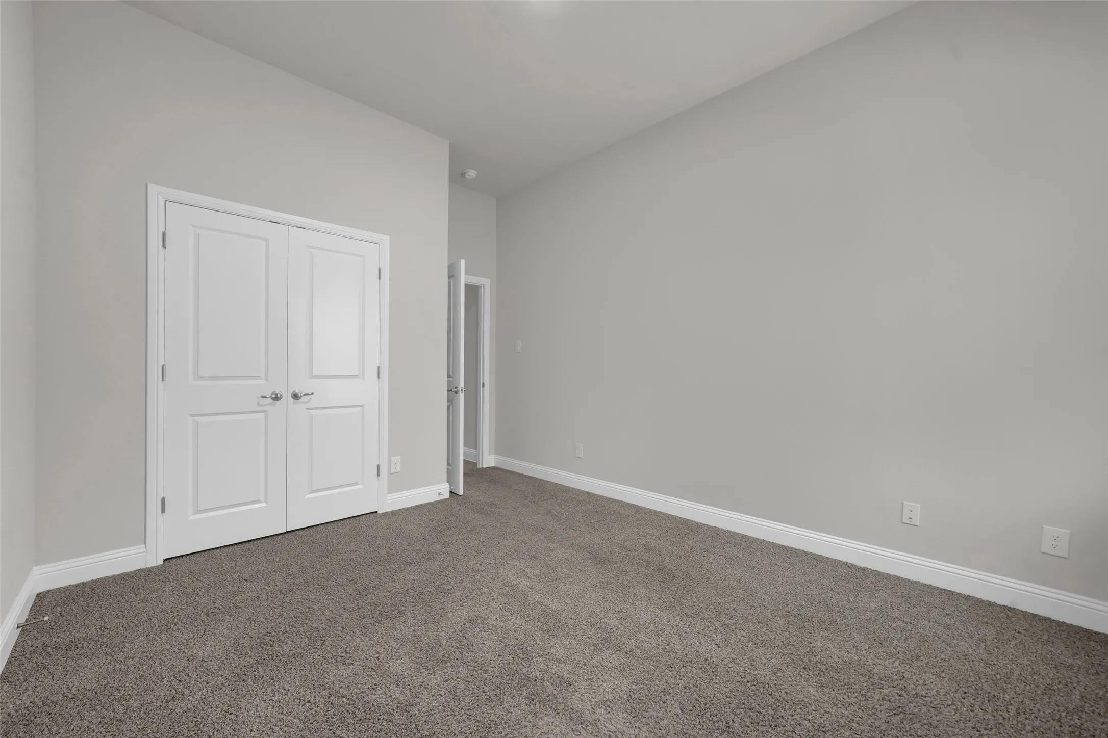 Neutral-toned walls complement the plush gray carpeting