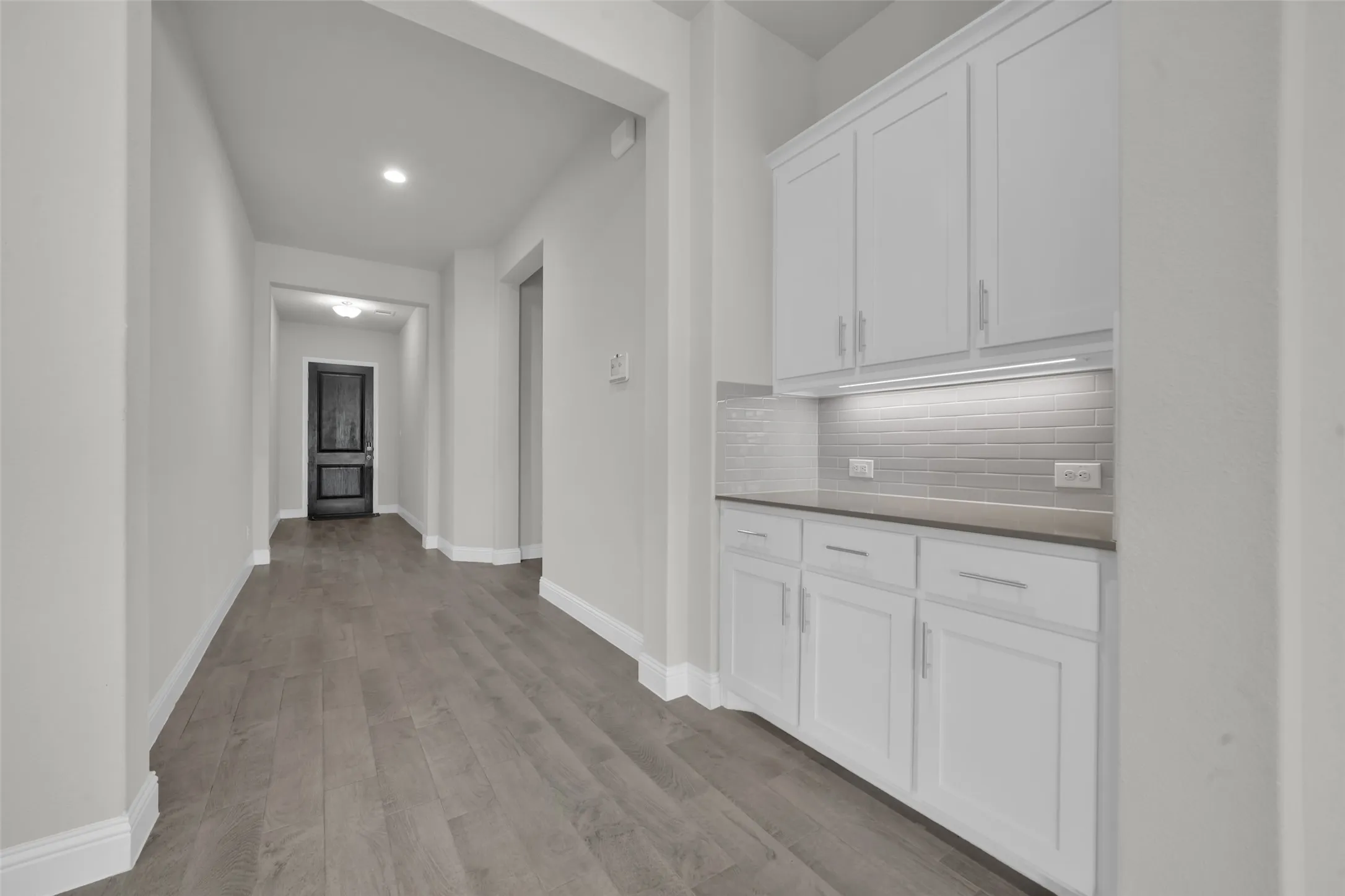 Hallway with wood-finish flooring and recessed lighting