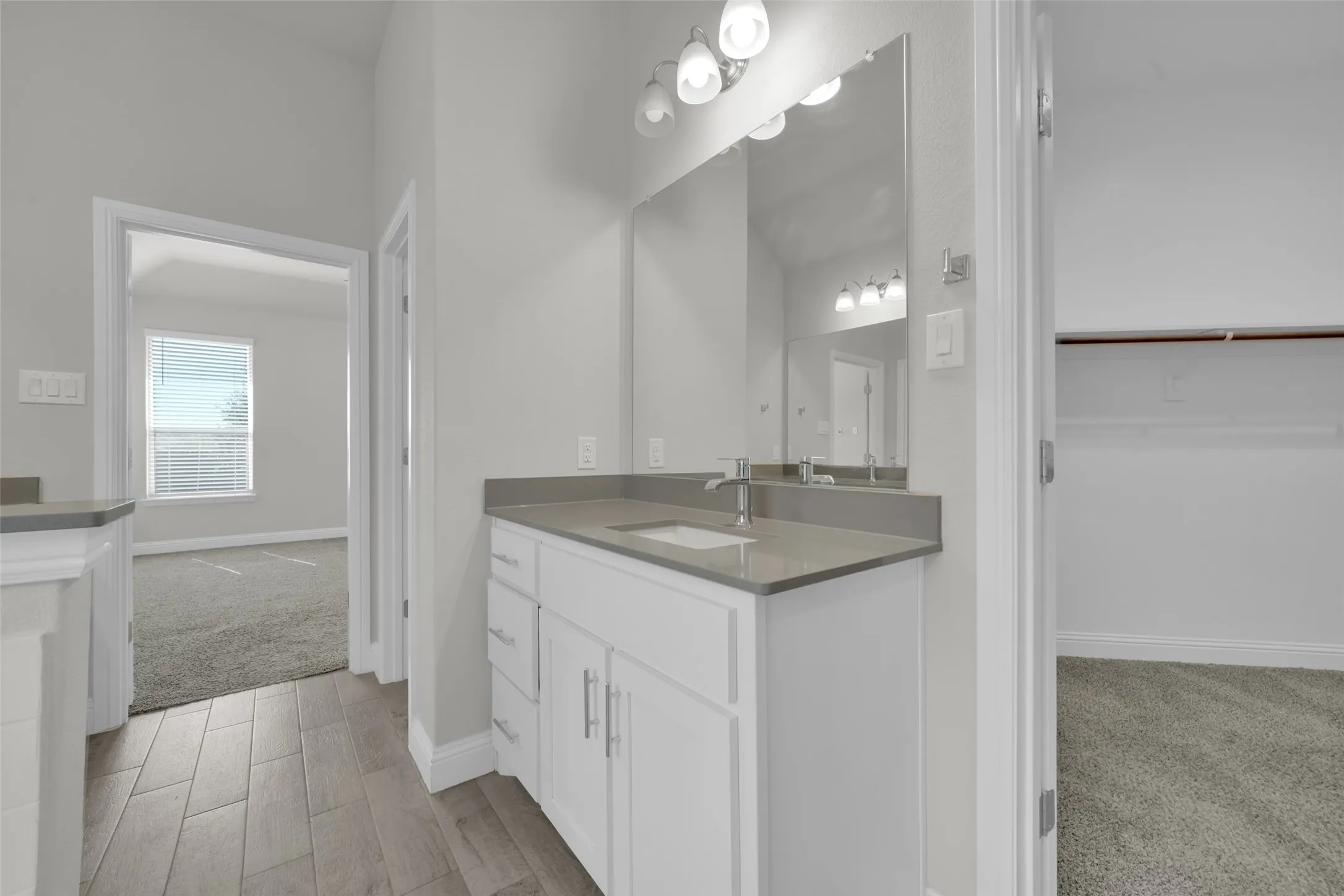 Modern vanity with a light gray countertop, white cabinetry, and a rectangular undermount sink