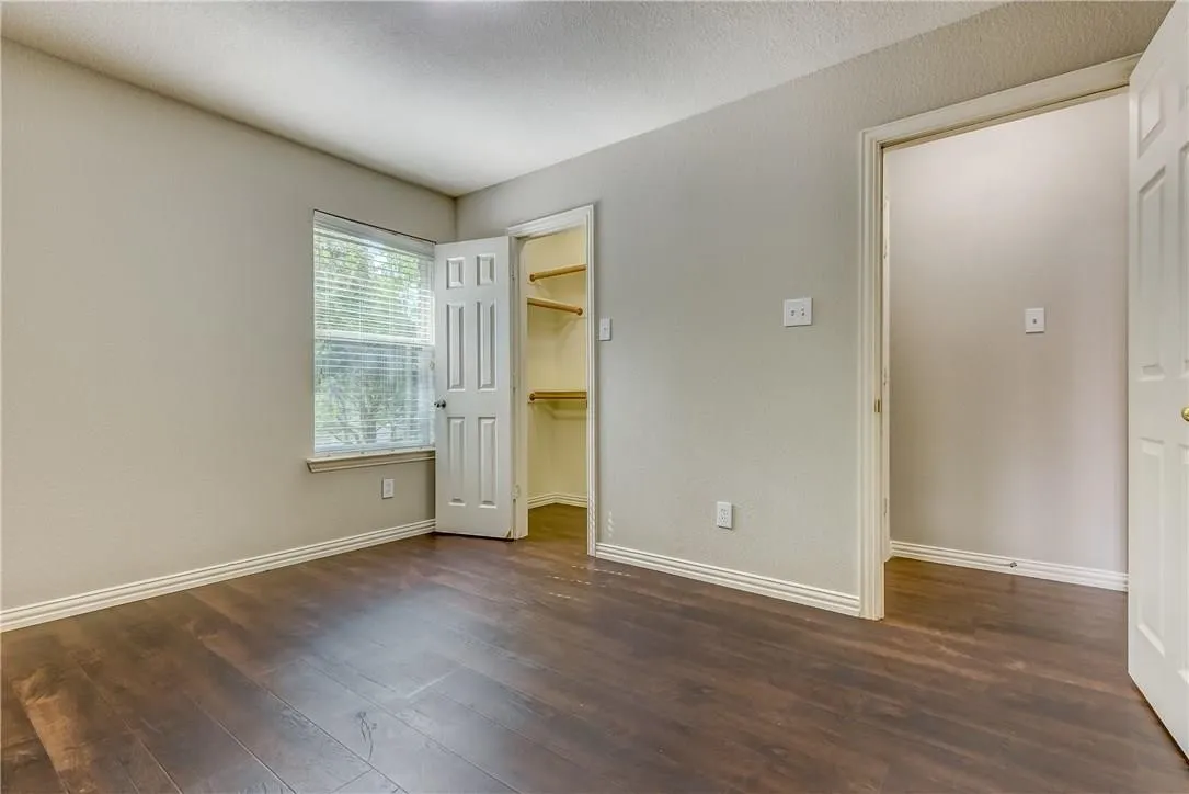 Empty room with dark hardwood / wood-style flooring