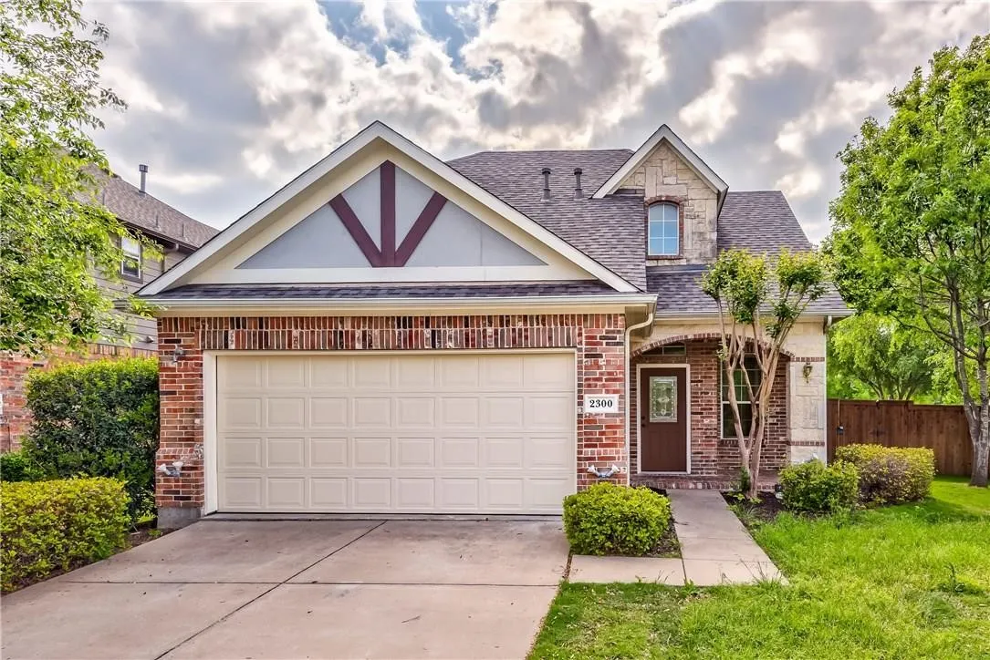View of front of property with a garage and a front lawn