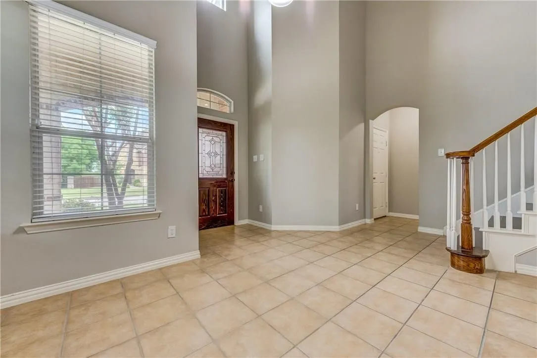 Tiled foyer with a towering ceiling