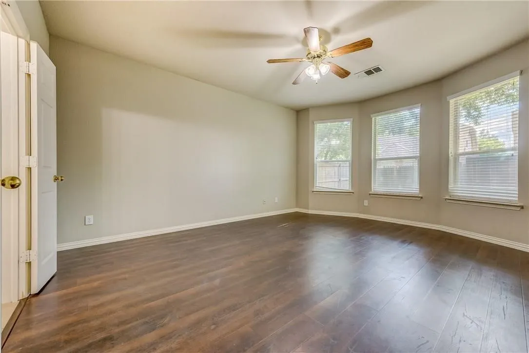 Spare room with ceiling fan and dark wood-type flooring