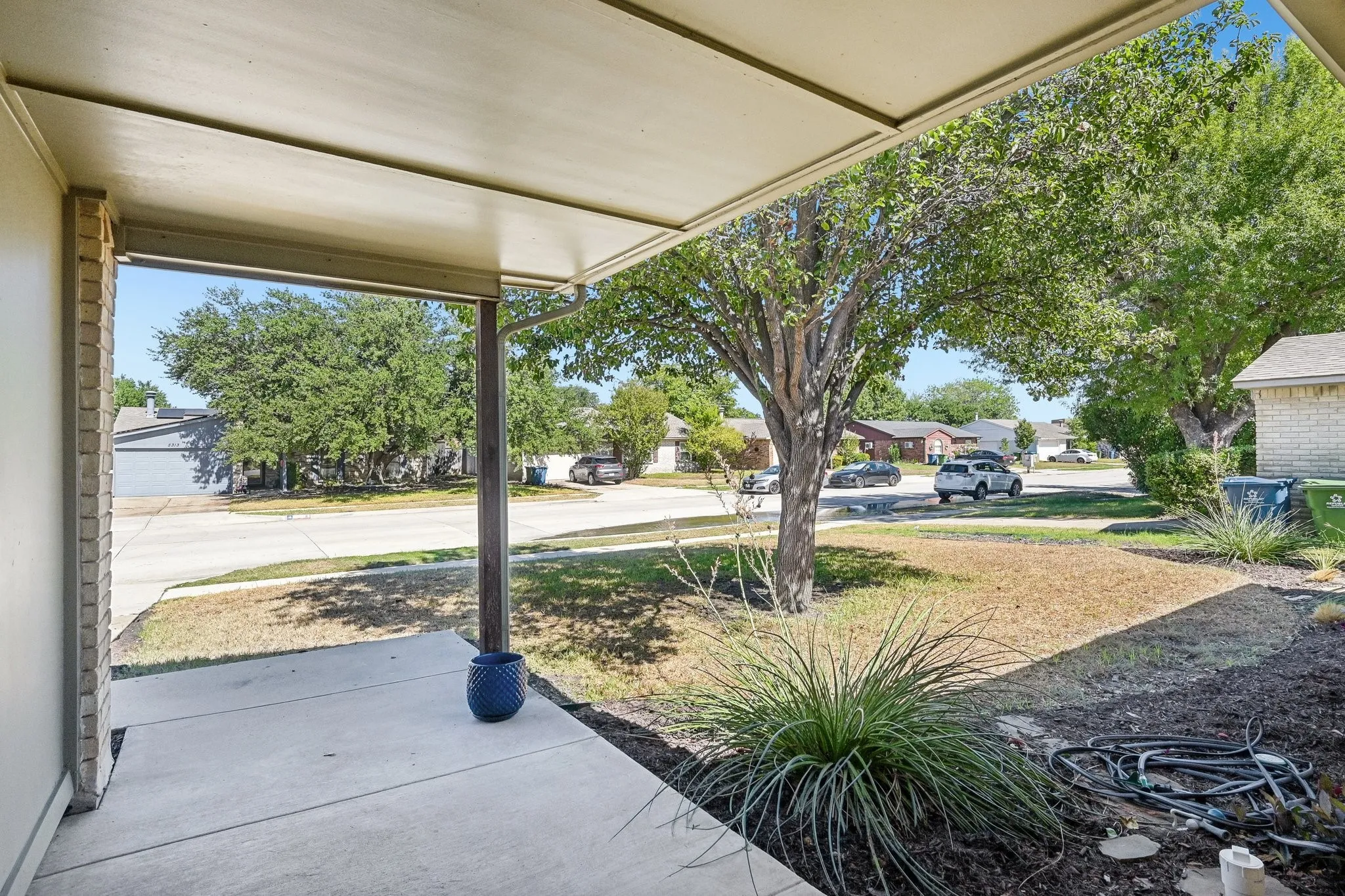 Covered porch with concrete flooring and a structural support column