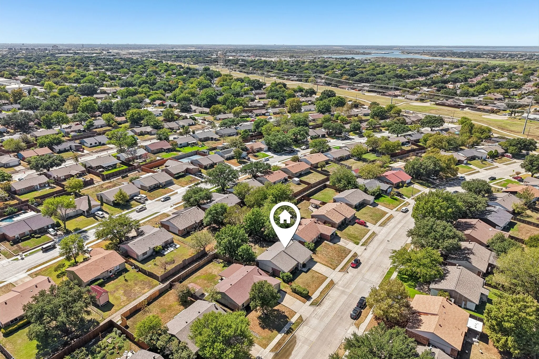 Aerial perspective of a residential neighborhood with tree-lined streets and established homes