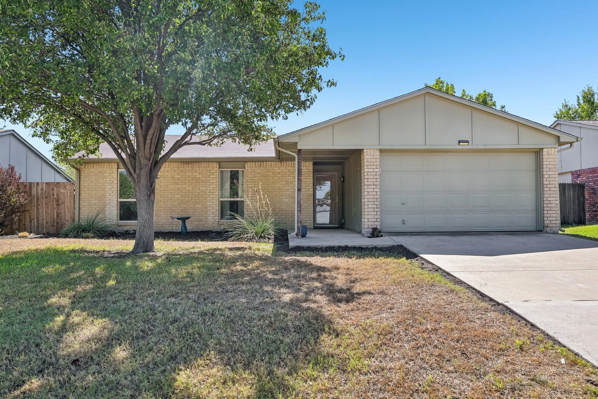 Brick exterior with a two-car garage and a concrete driveway