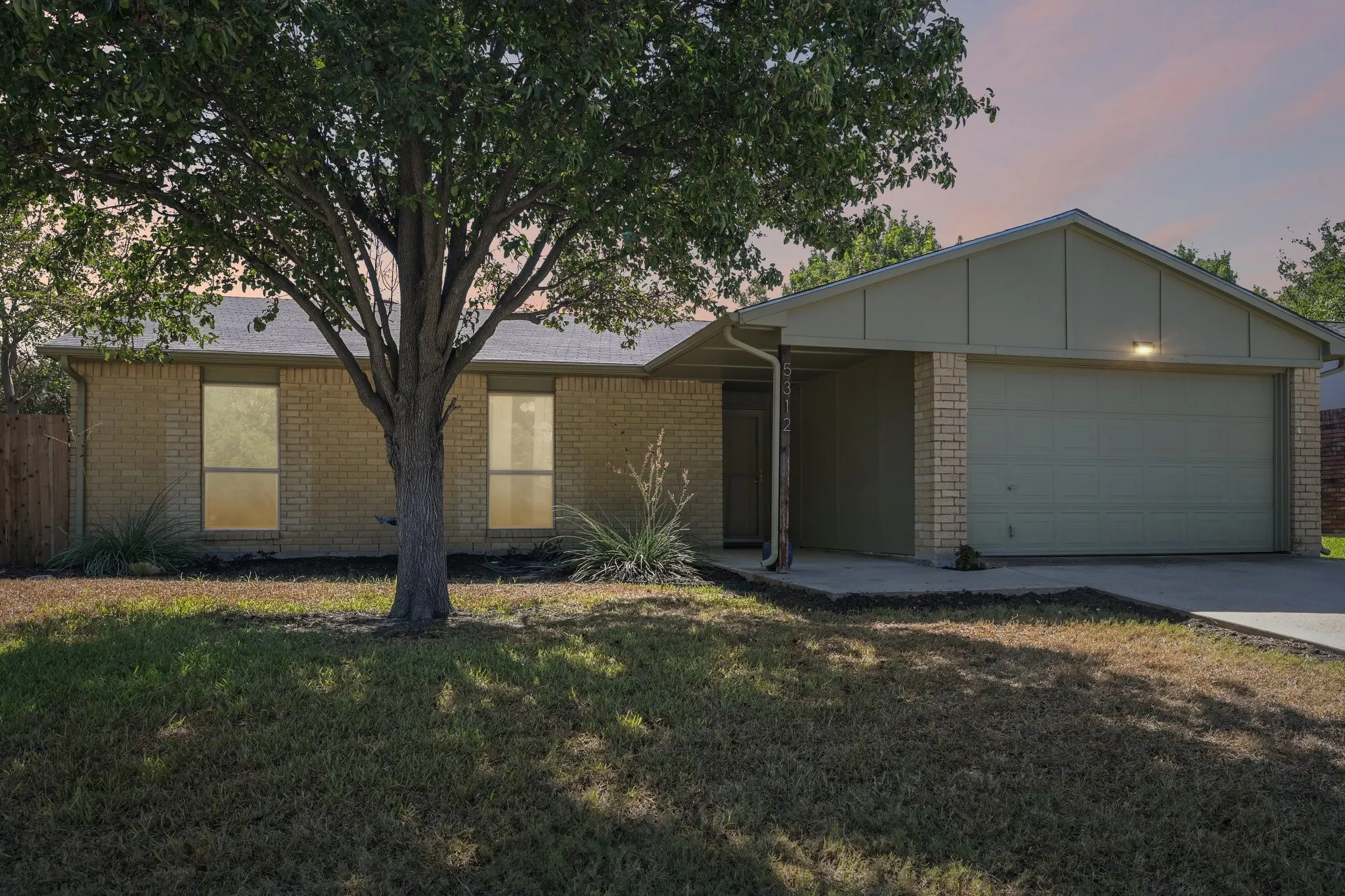 Brick exterior with an attached garage, covered entry, and concrete driveway