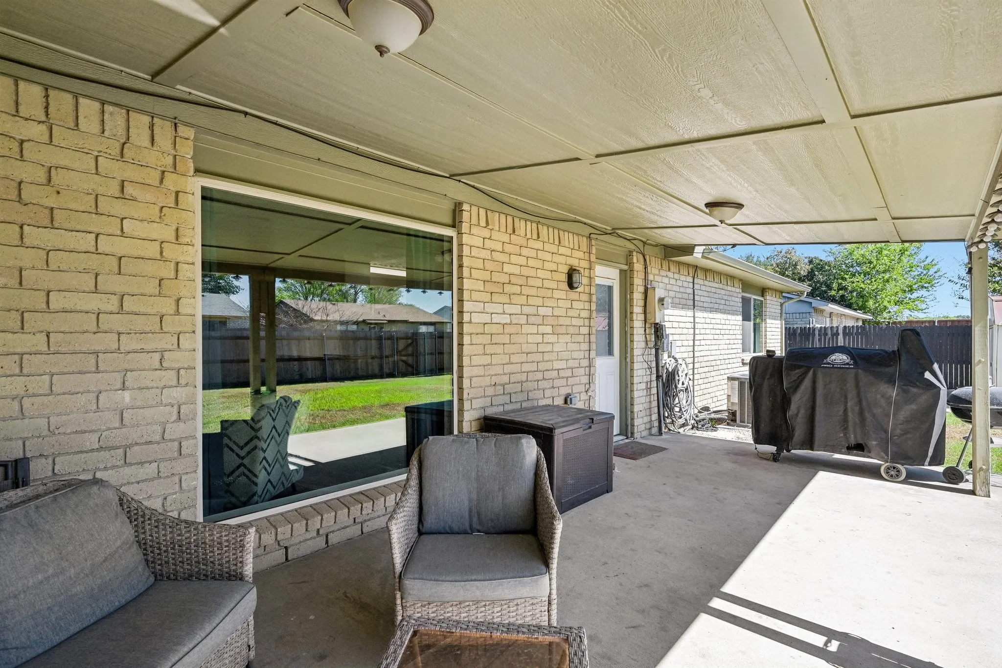 Covered patio with a concrete surface, brick exterior, and recessed lighting fixtures