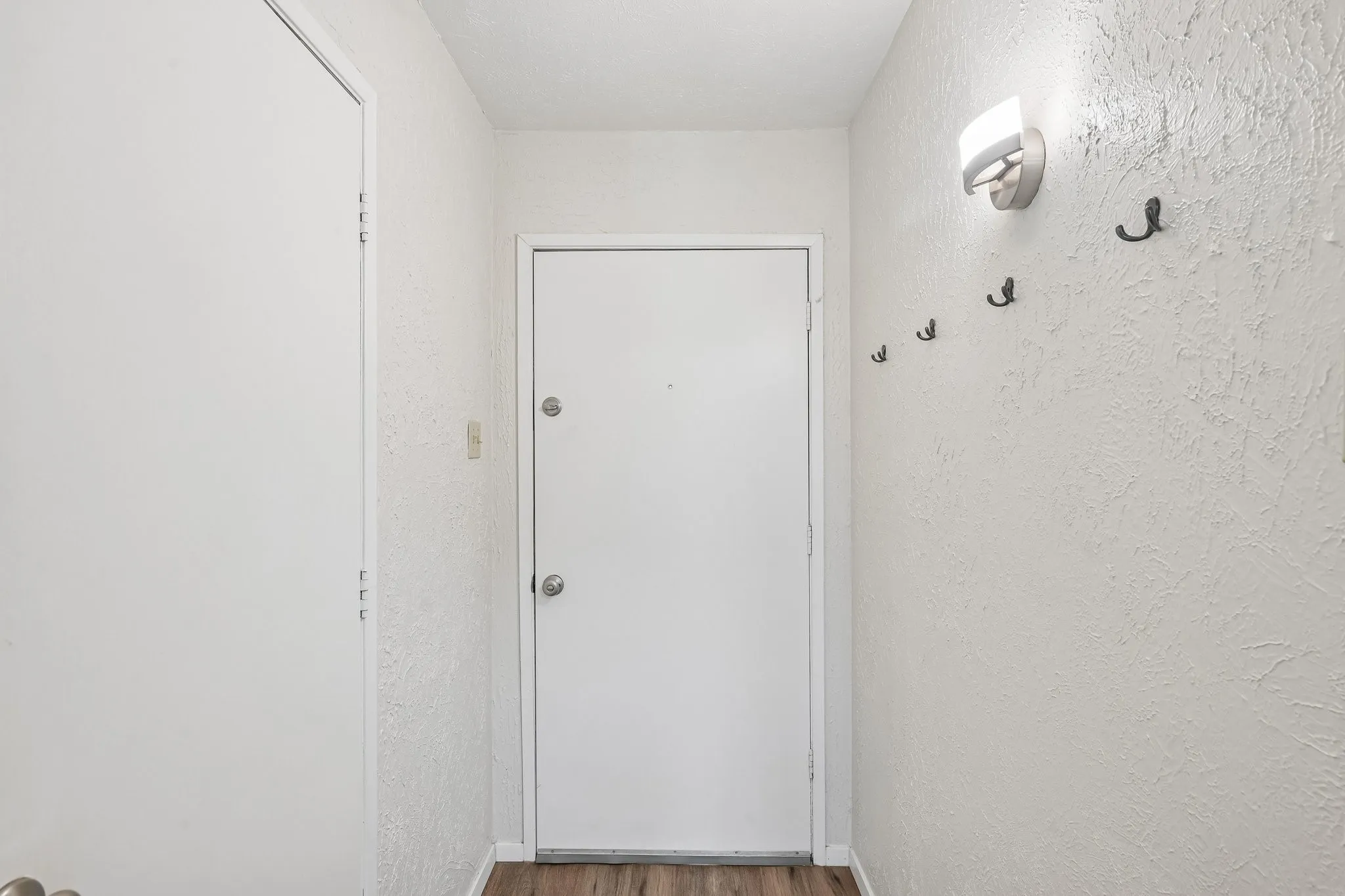 LVP flooring with white doors and textured wall finish