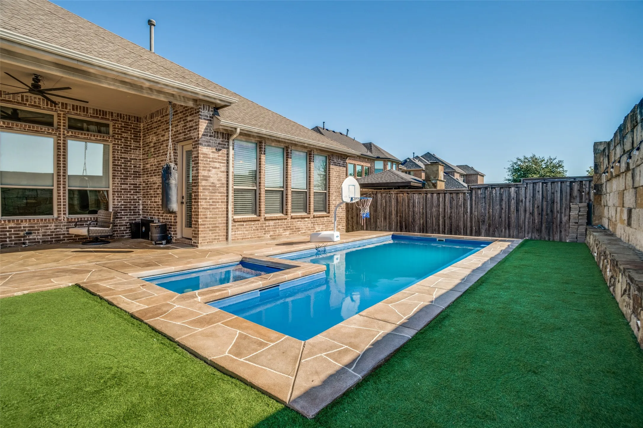 Outdoor swimming pool with integrated spa and stone coping