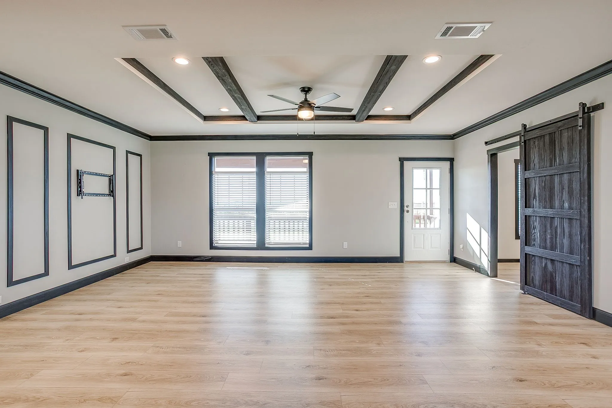 Tray ceiling with recessed lighting and dark wood beams