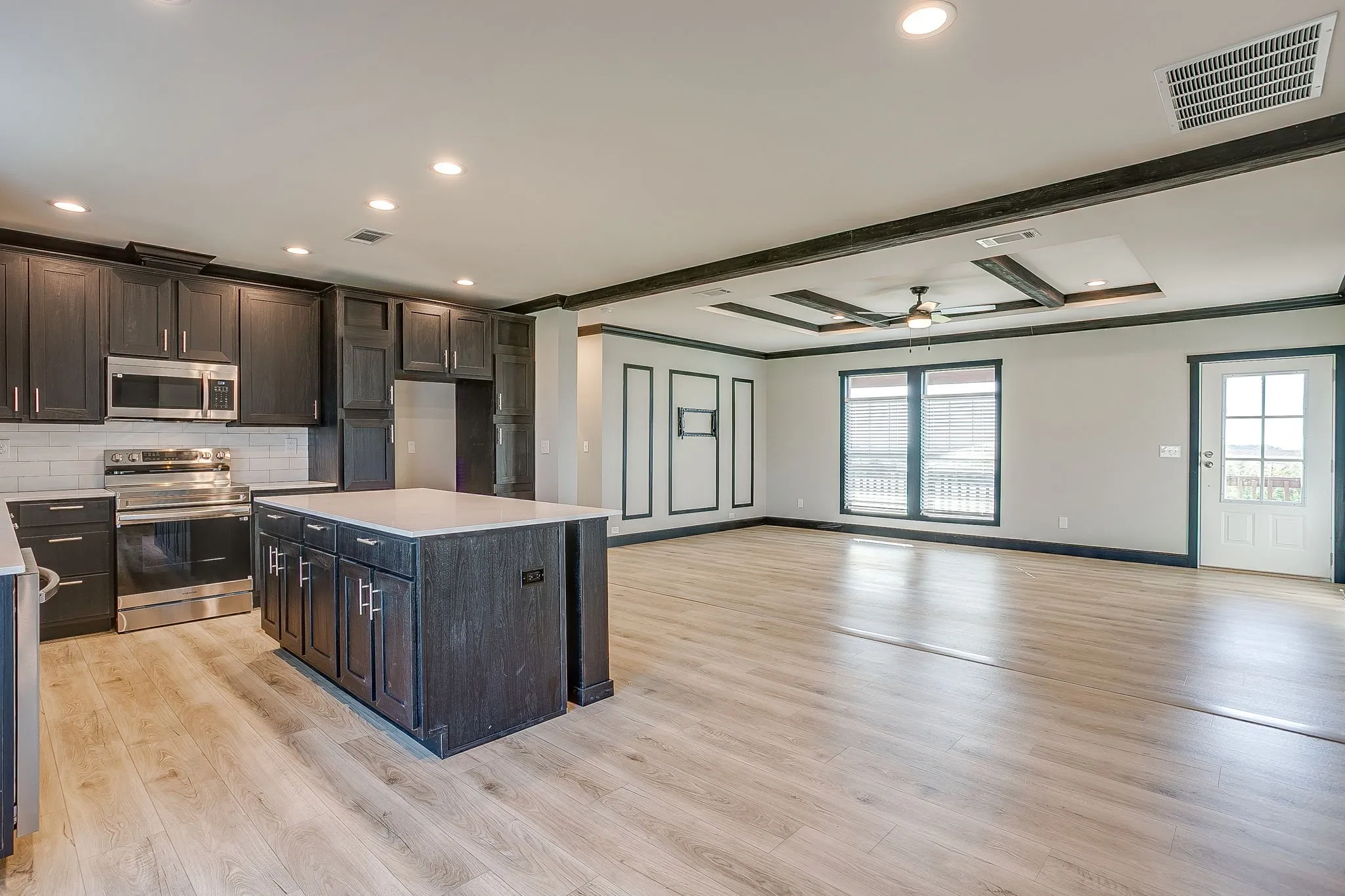 Open-concept kitchen and living area featuring wood-finish flooring