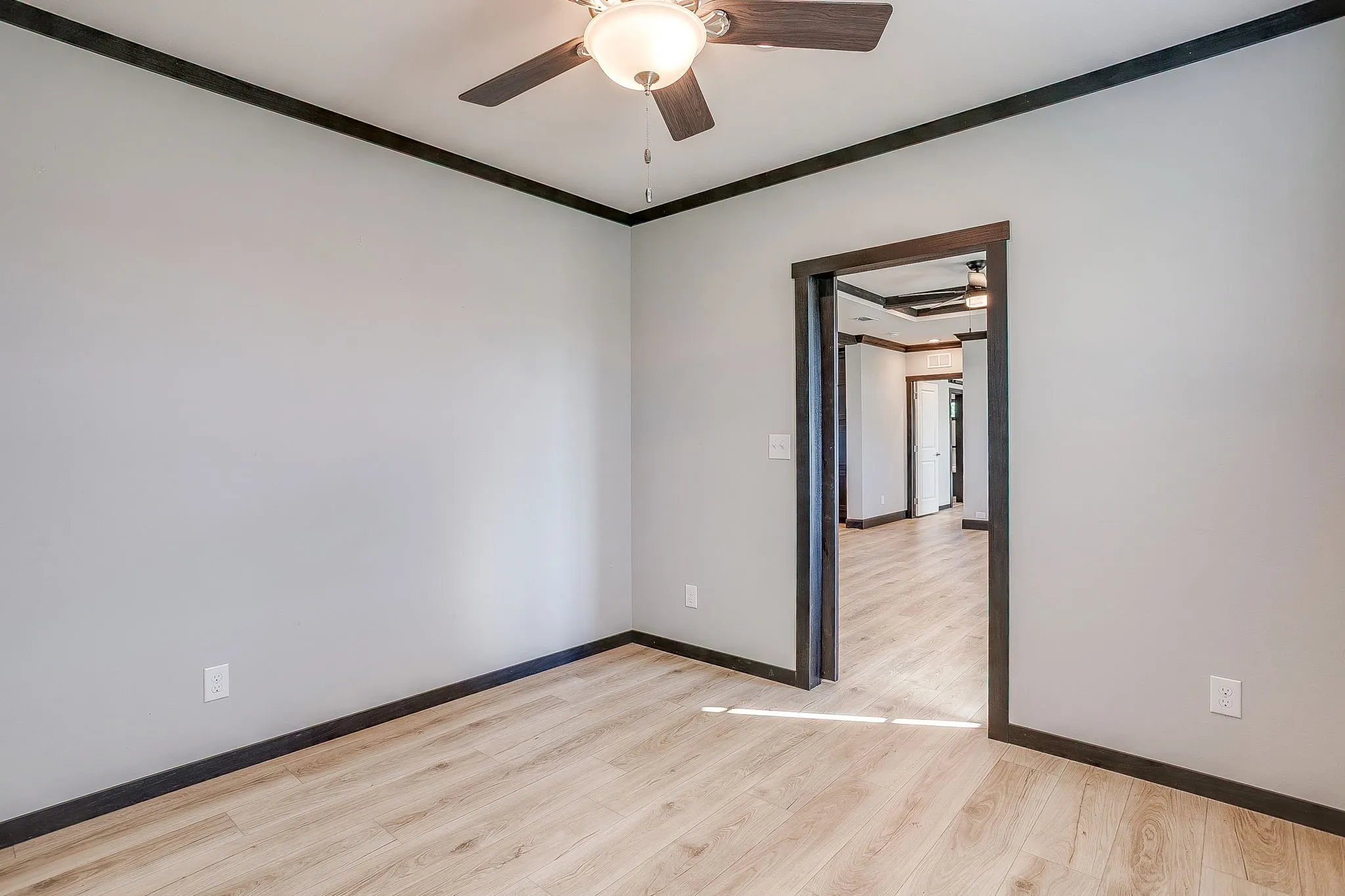 Light wood-finish flooring with dark trim accents