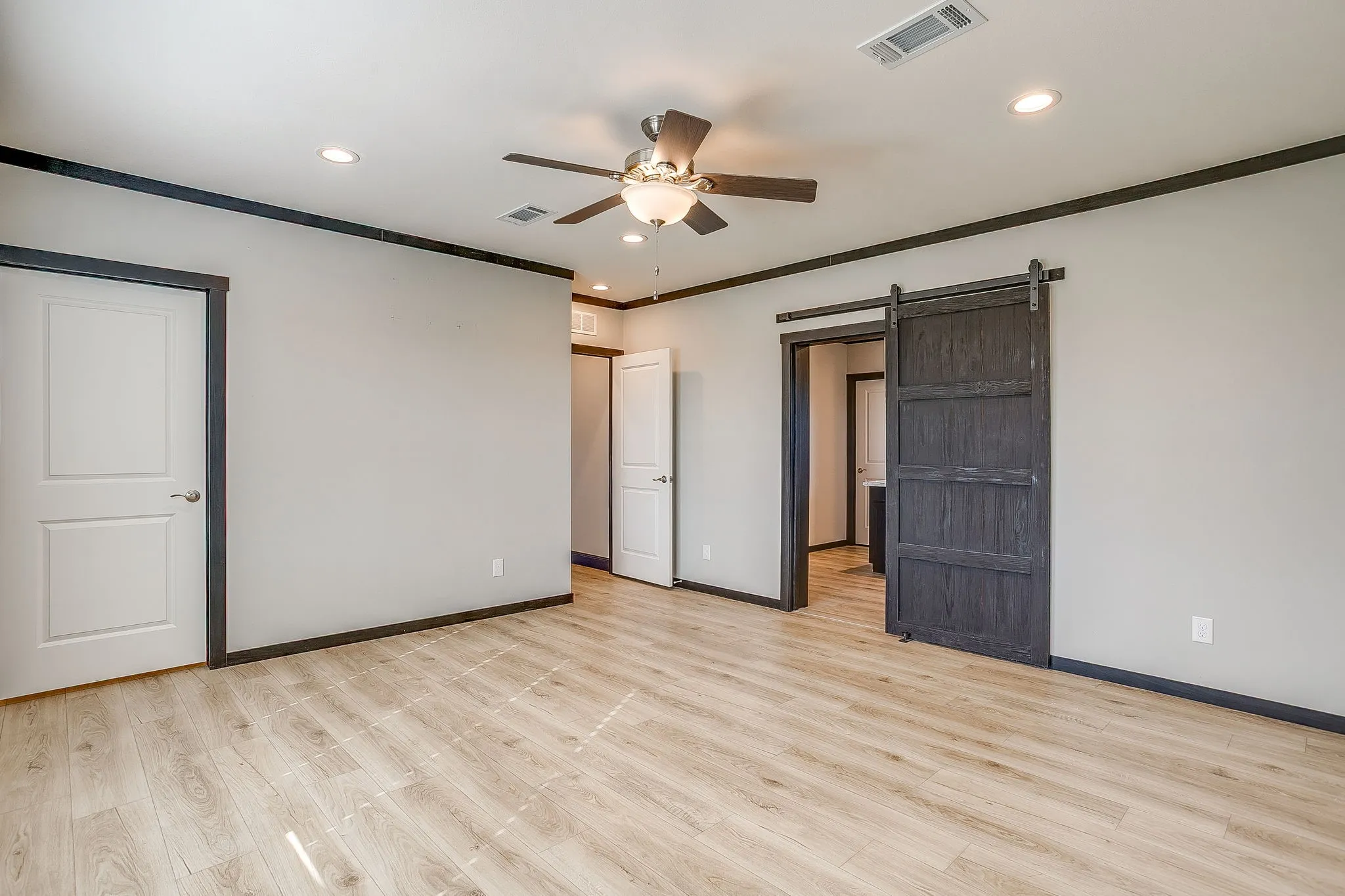 Wood-finish flooring throughout, with a ceiling fan and recessed lighting