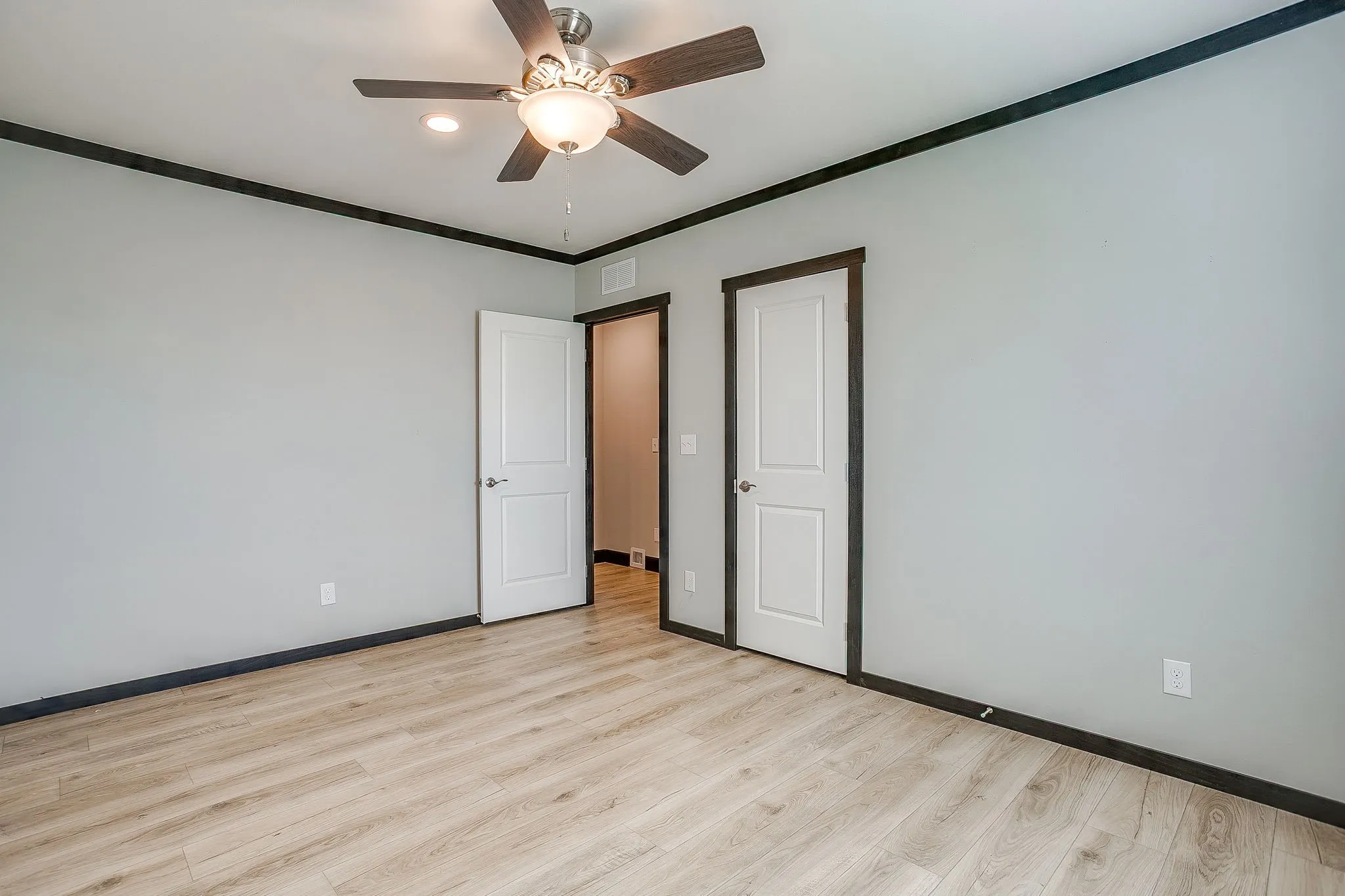 Light wood-finish flooring with dark trim details