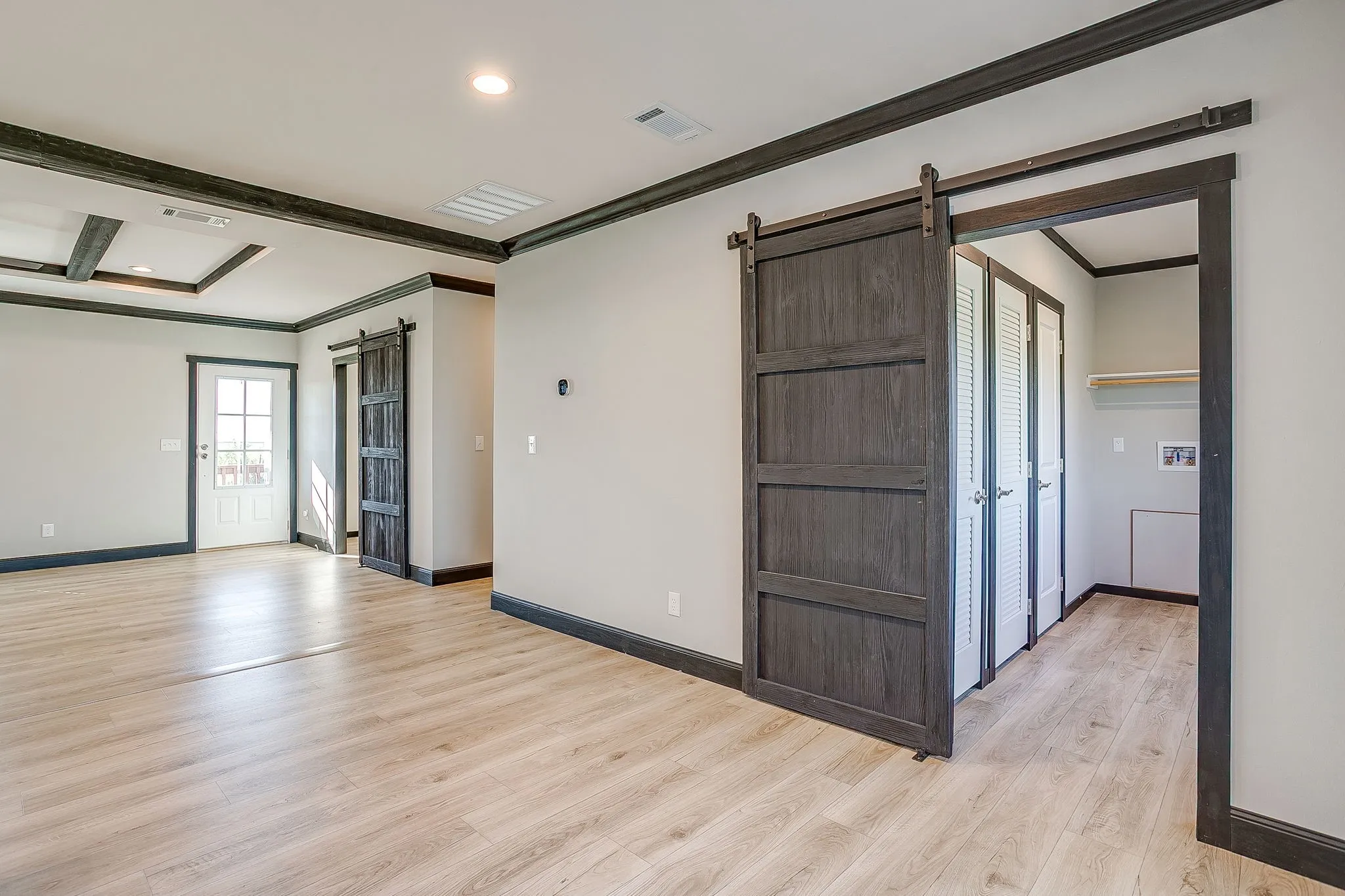 Wood-finish flooring throughout, featuring a coffered ceiling and dark trim accents
