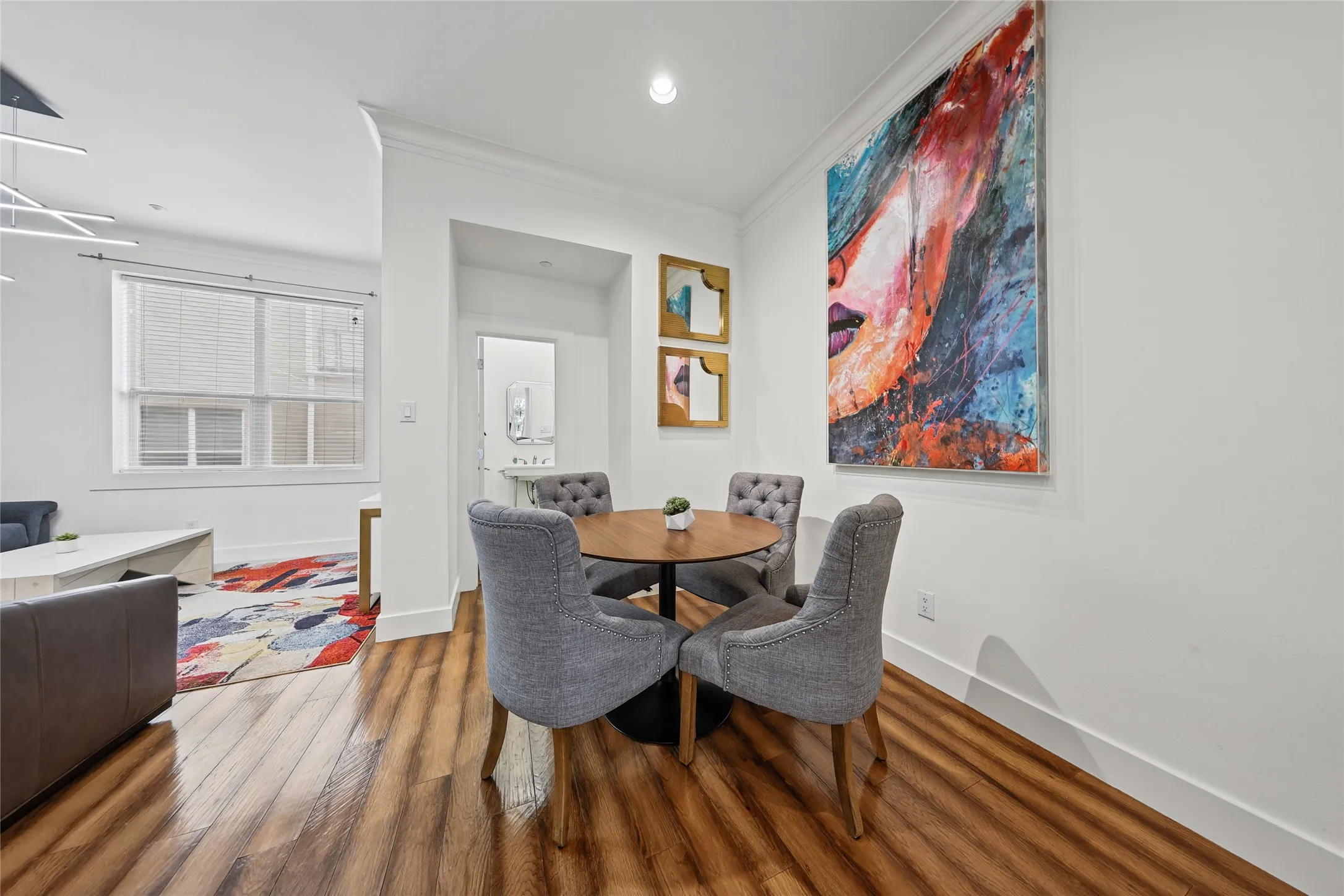 Wood-finish flooring throughout, white walls, and crown molding