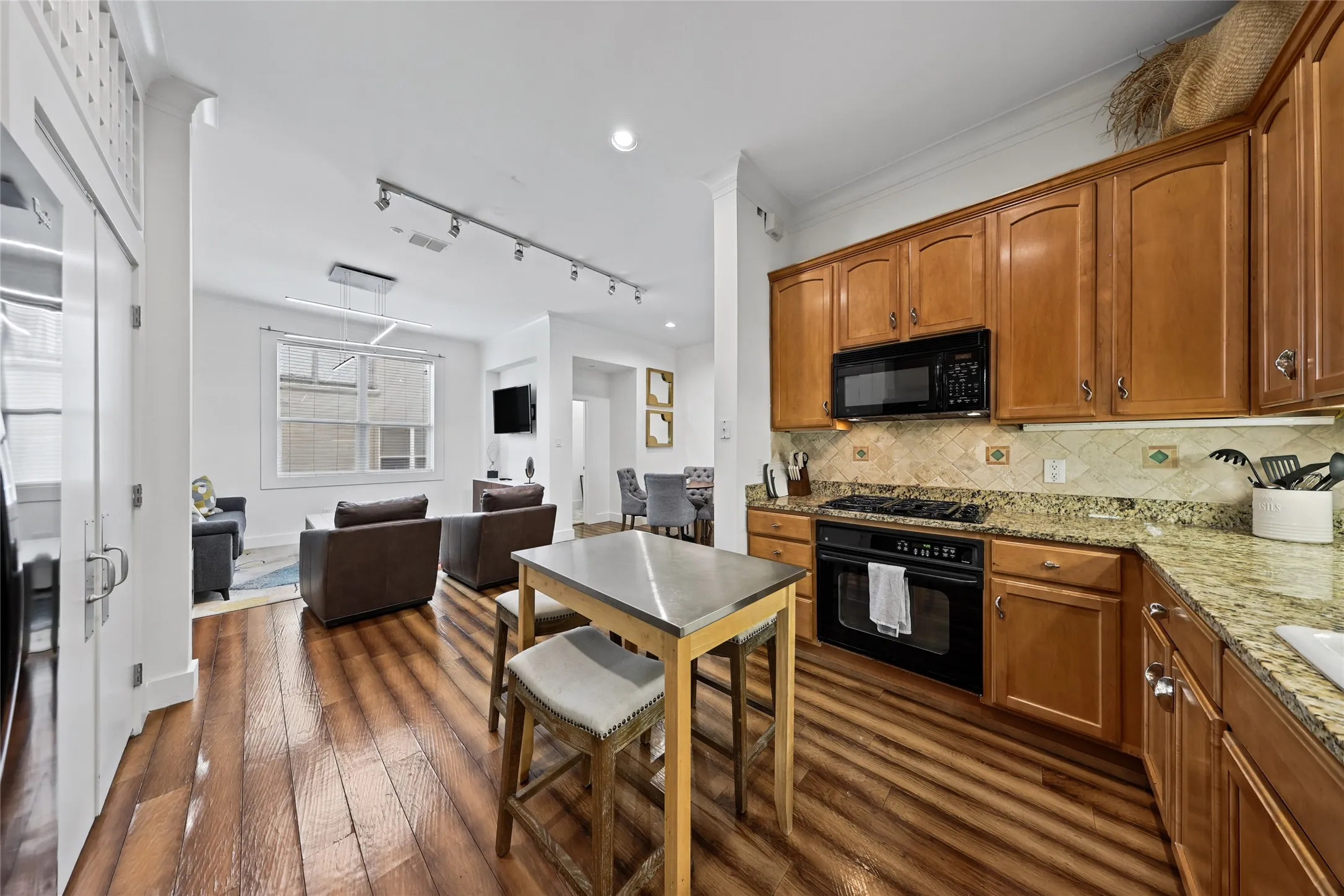Kitchen featuring wood-finish cabinetry, granite countertops, and a tile backsplash