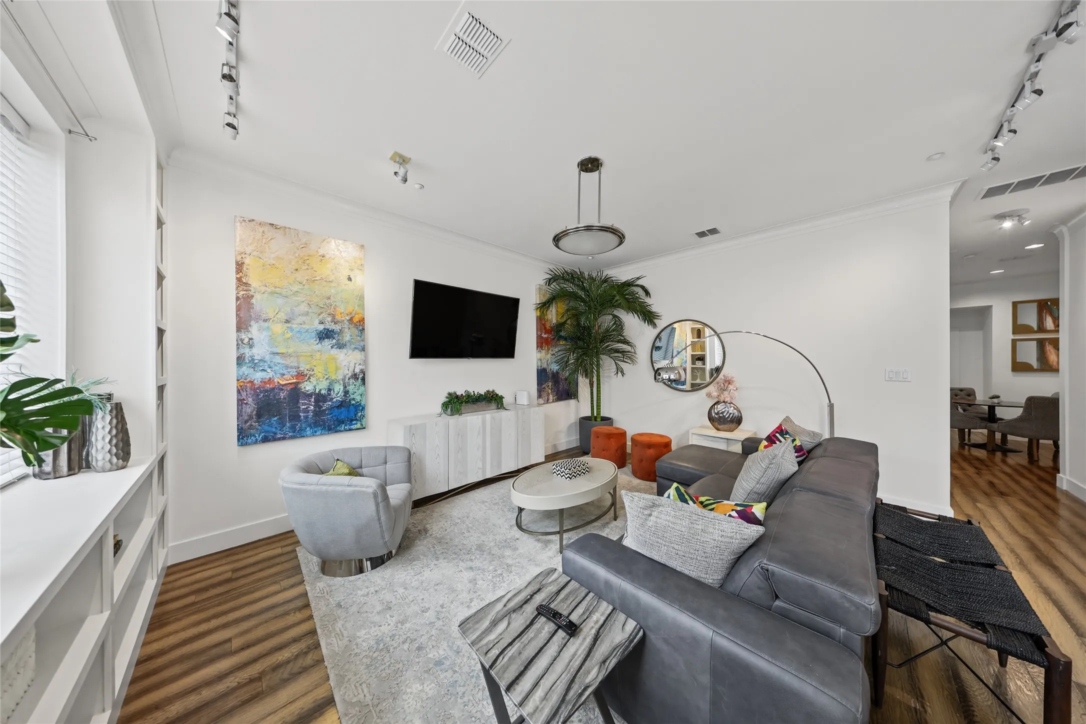 Hardwood-finish flooring, built-in shelving, white walls, recessed lighting, and a modern ceiling fixture