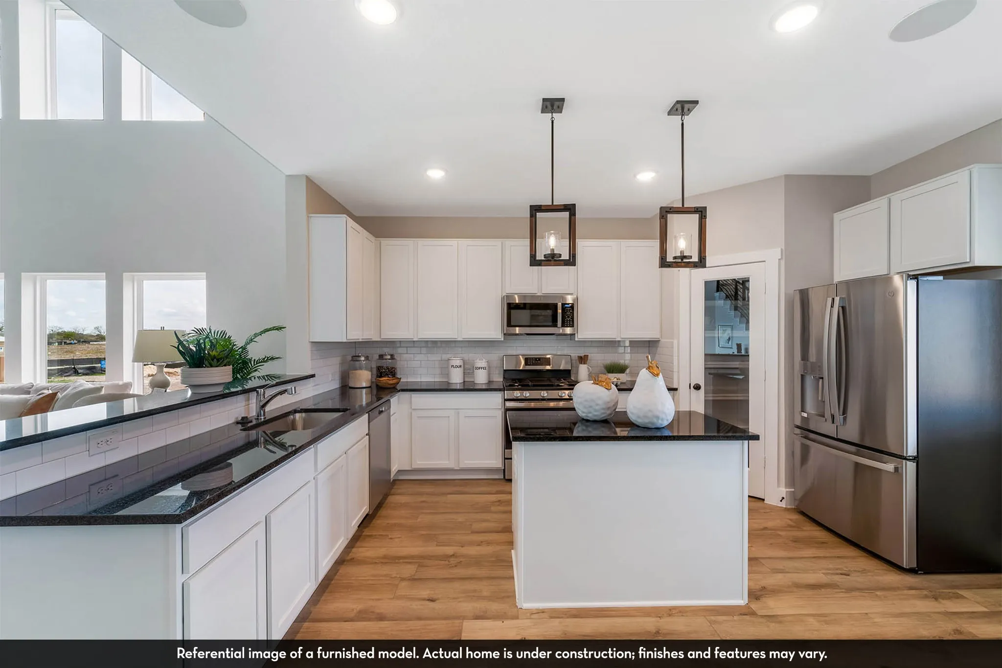 Kitchen featuring stainless steel appliances, white cabinetry, dark countertops, wood-finish flooring, and an island