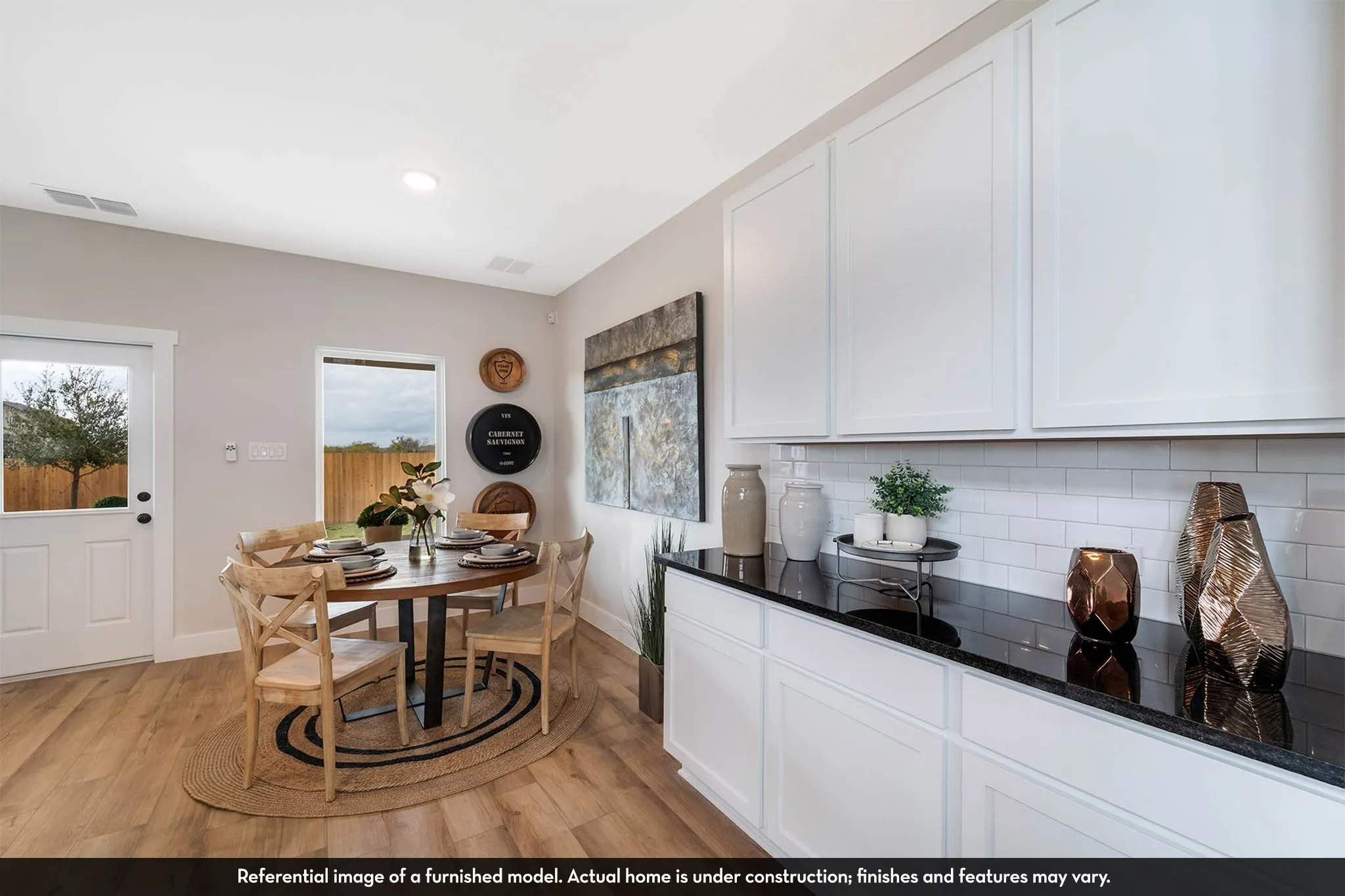 Wood-finish flooring, white cabinetry, dark stone countertops, white subway tile backsplash, and recessed lighting