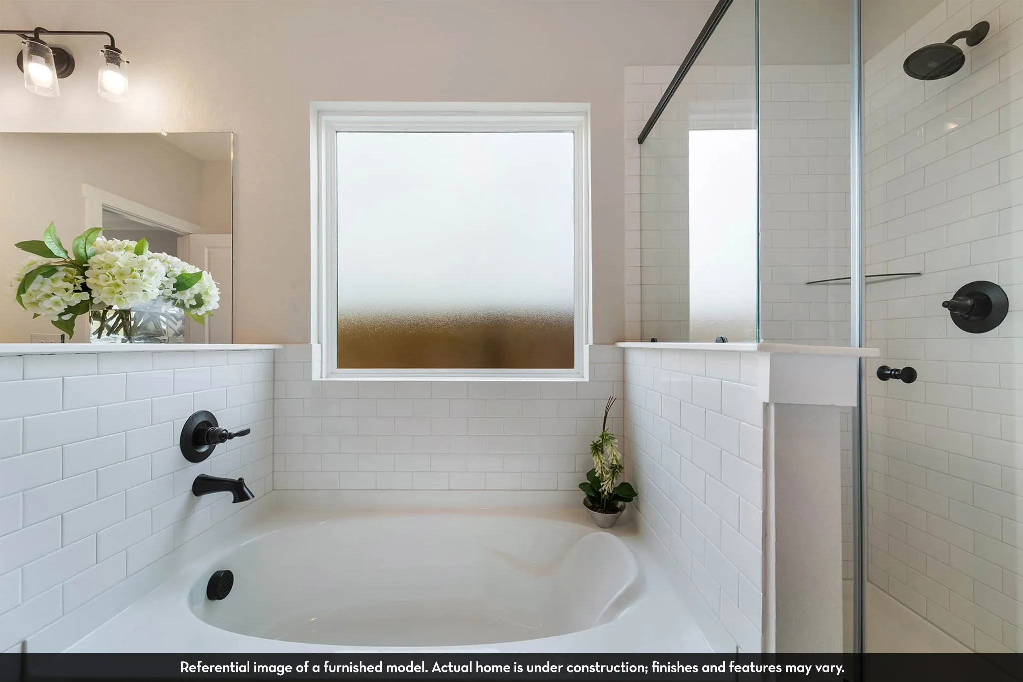 Built-in soaking tub, subway tile surround, matte black fixtures, frosted window, and glass-enclosed shower
