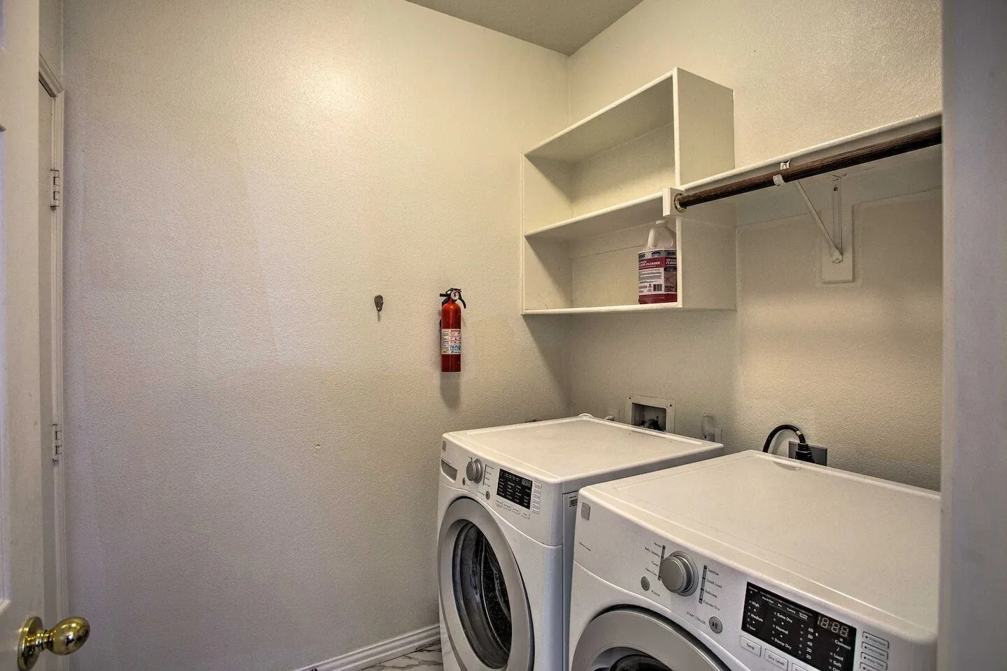Laundry area featuring built-in shelving and a clothing rod