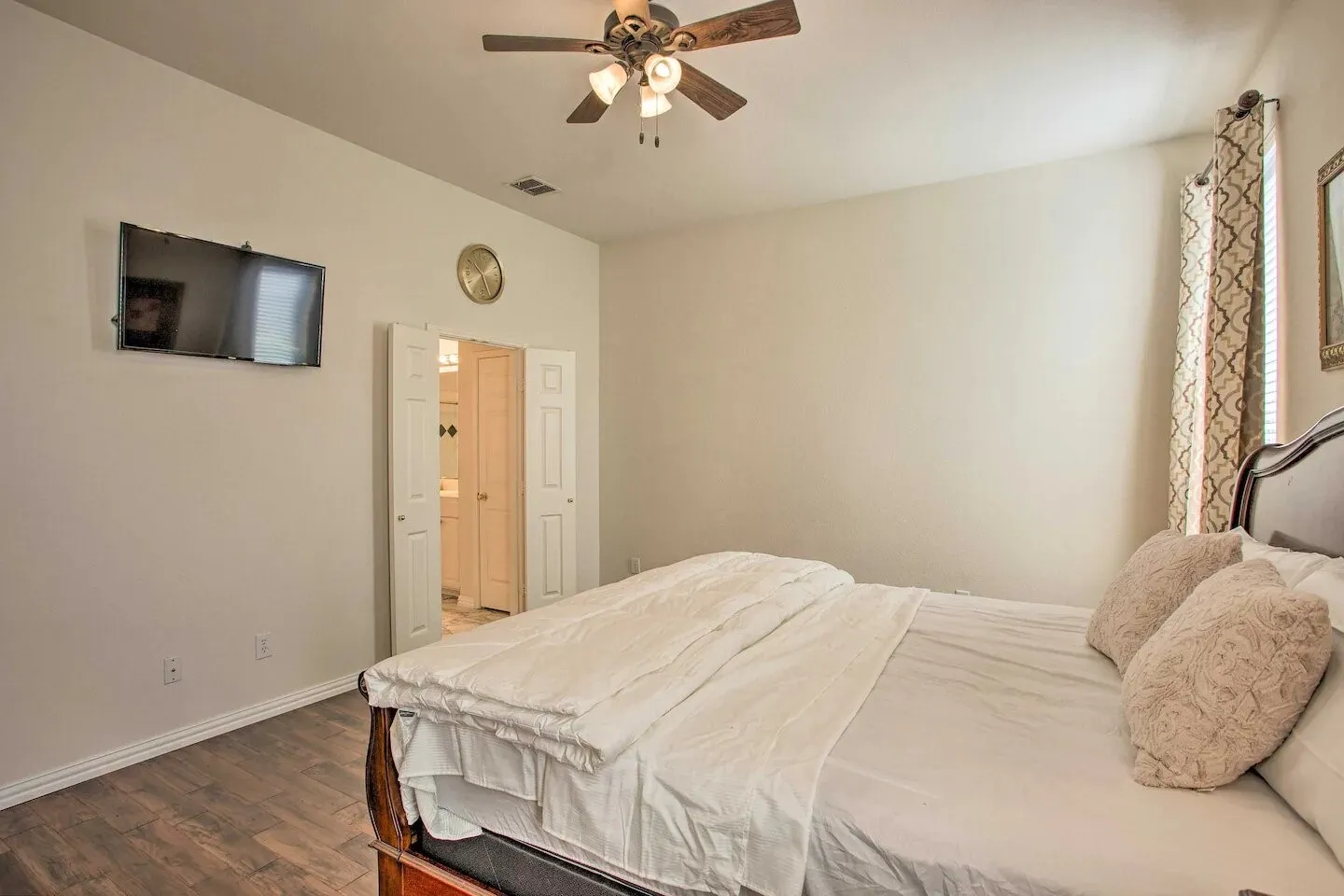 Vaulted ceiling with a ceiling fan, wood-finish flooring, and double bi-fold doors