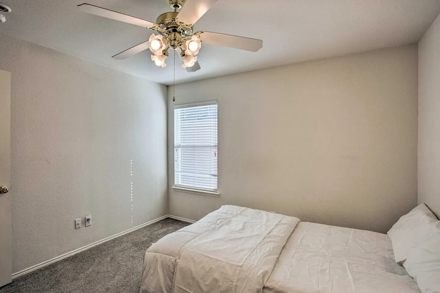 Recessed window with blinds, ceiling fan with integrated lighting, and carpeted flooring